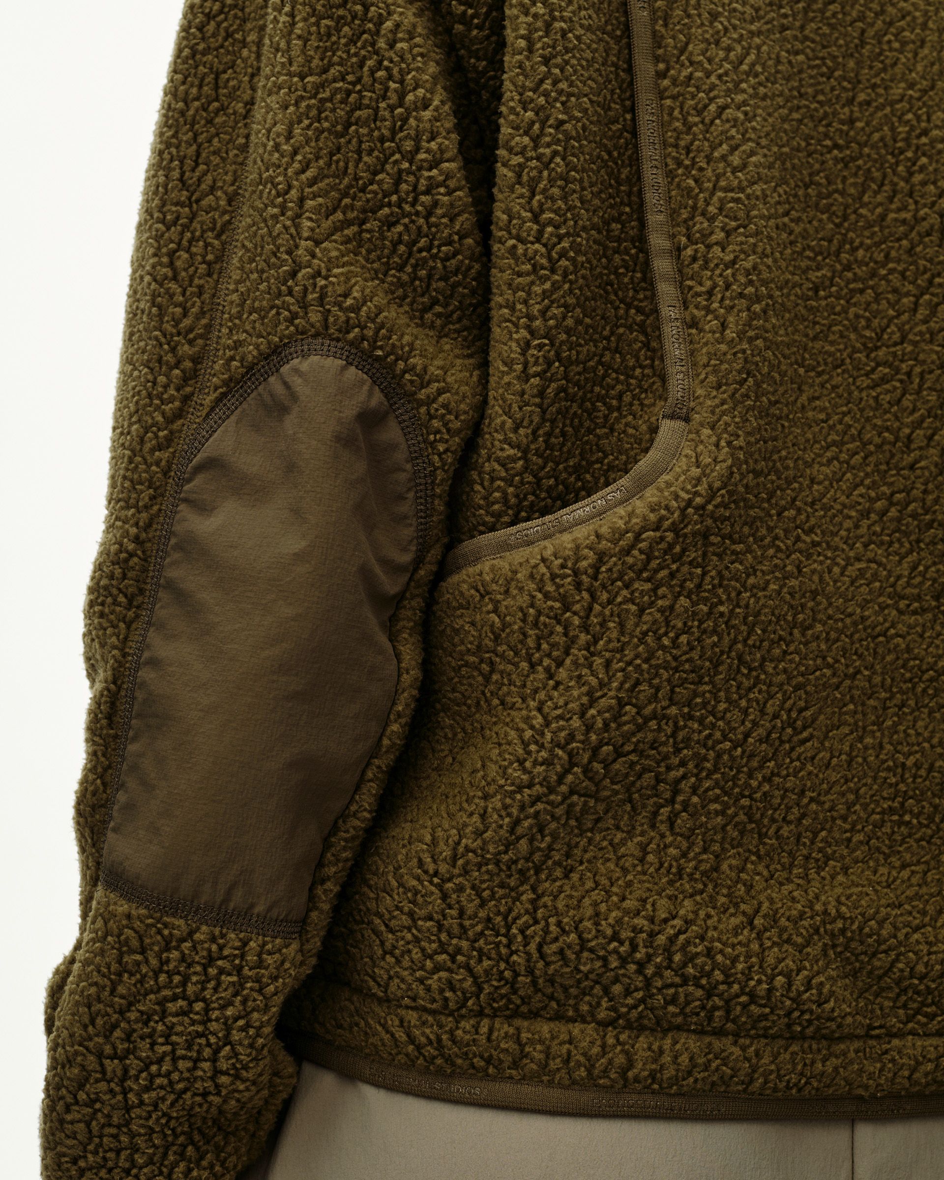 Deep Olive Off-Race Pile Fleece jacket, side detail on model with elbow patch and chest pocket trim