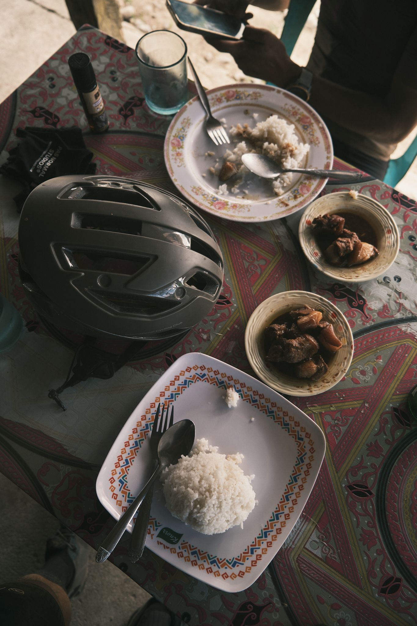 Black cycling helmet on table with traditional meal and patterned tablecloth
