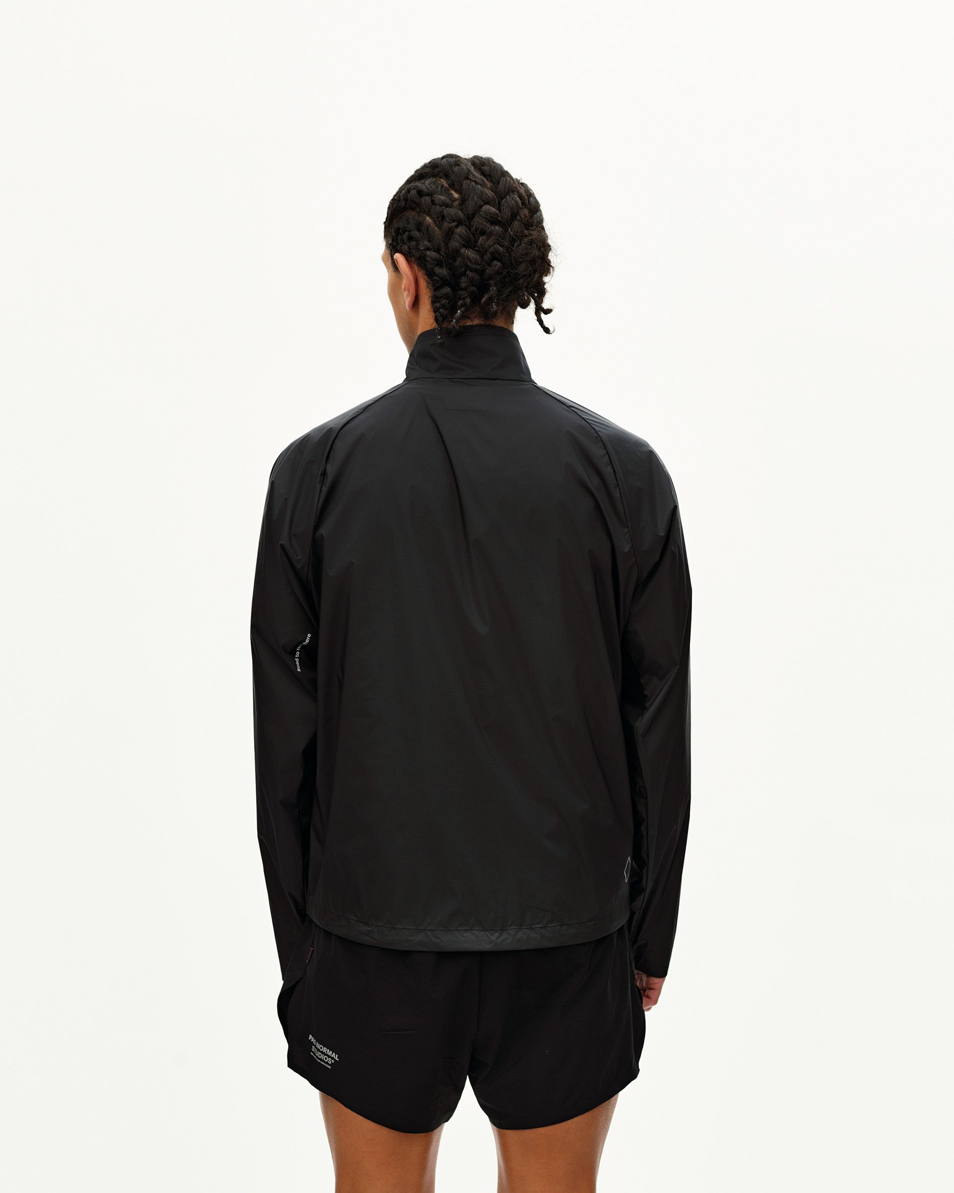 Black Balance Windproof jacket on model, rear view with contrast hem panel