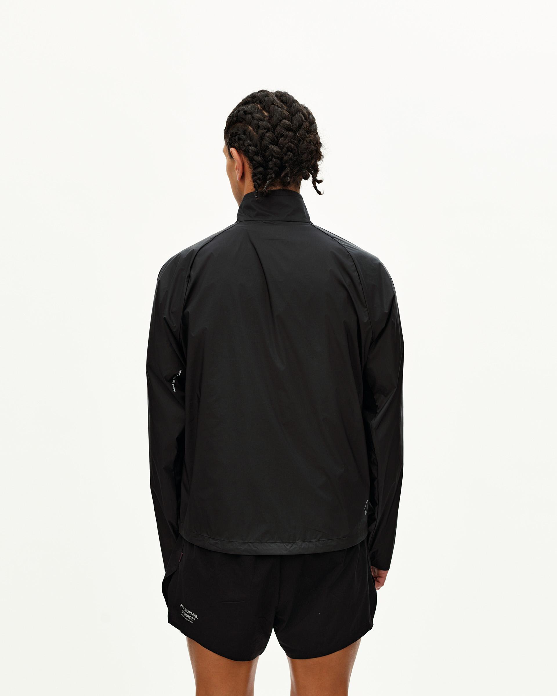 Black Balance Windproof jacket on model, rear view with contrast hem panel