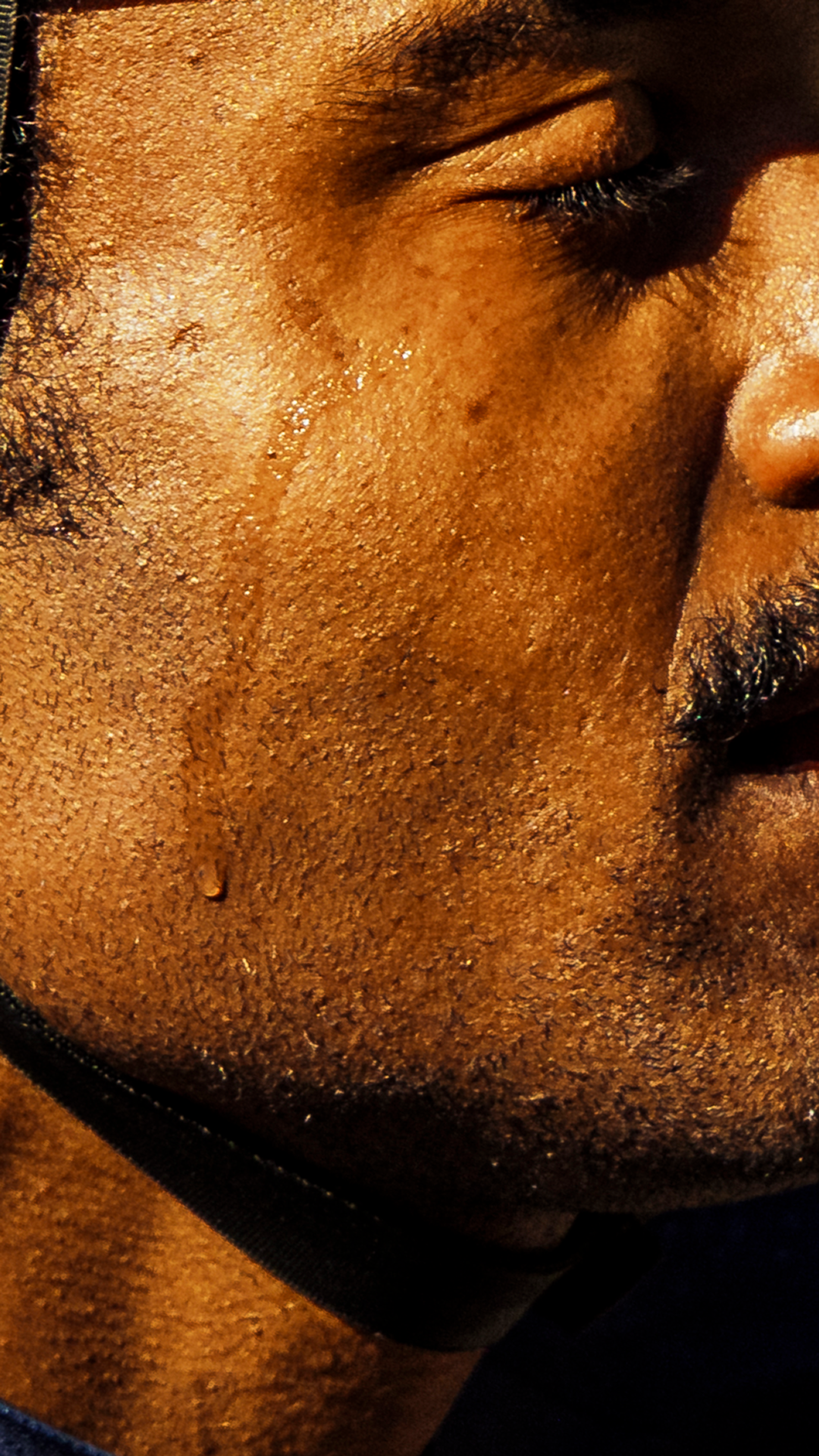Close-up of cyclist's face with water droplets and sweat during intense training