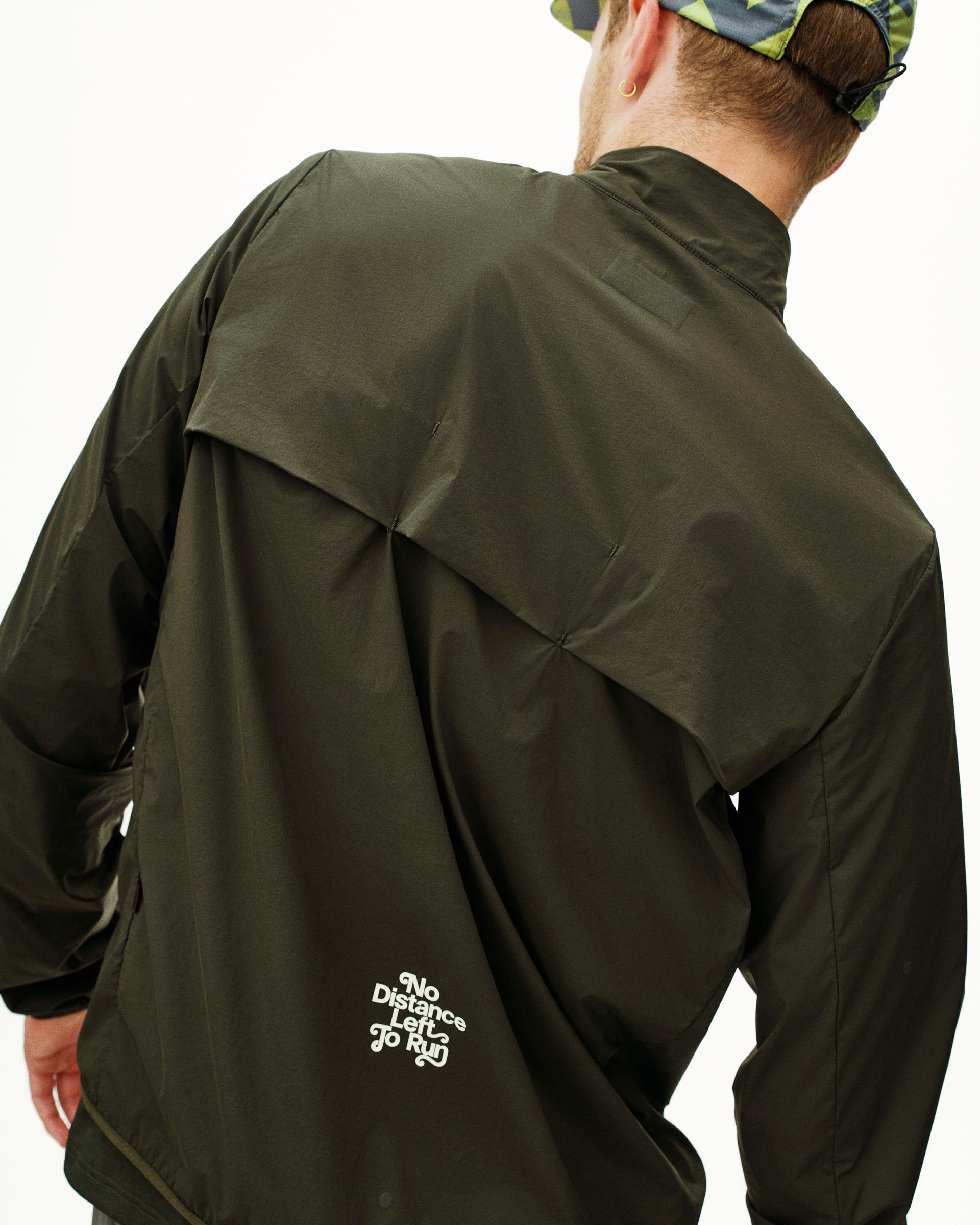 Dark Olive Balance Half Zip jacket, rear view on model with white text print