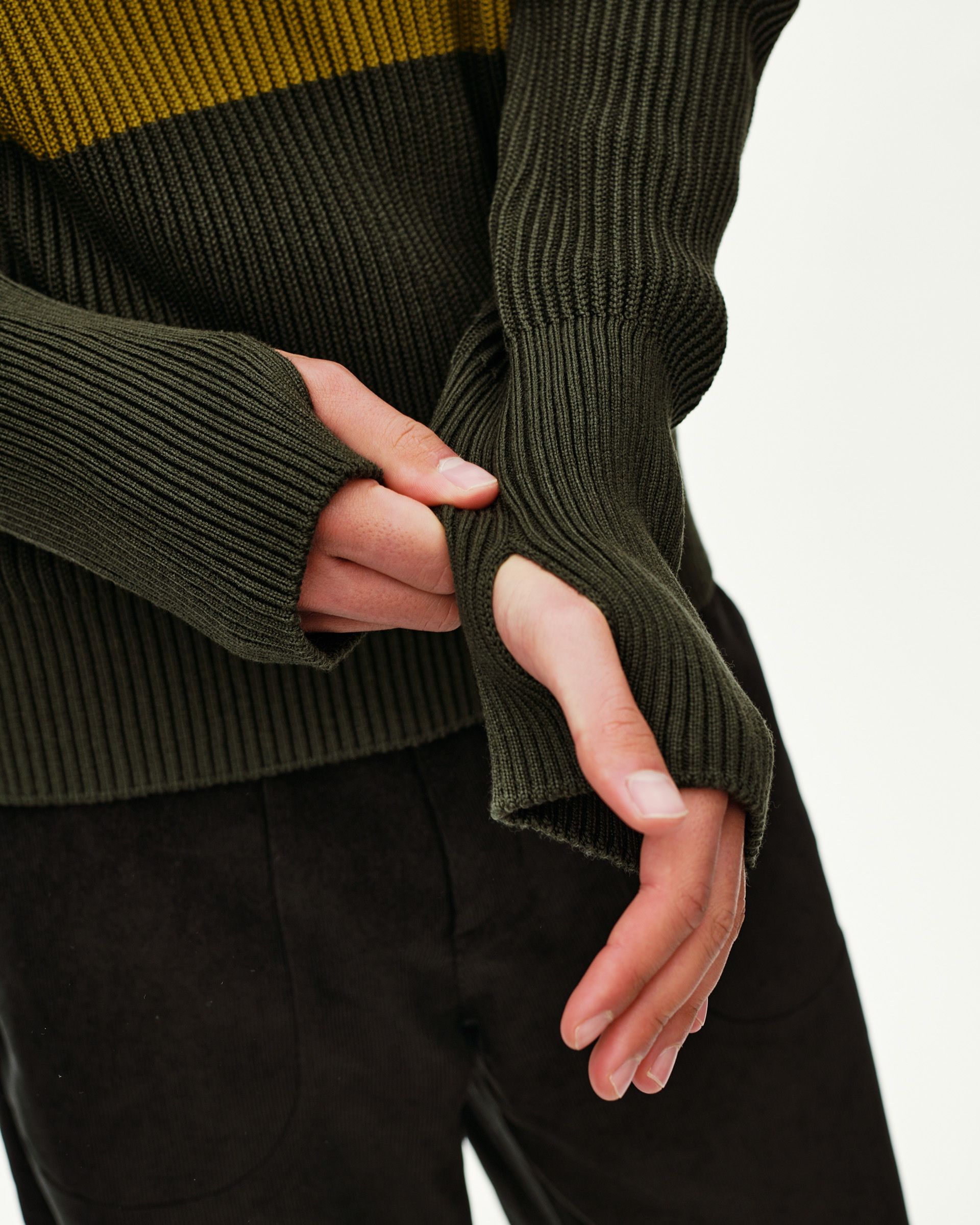Olive Off-Race Merino Knit Half-Zip sweater, detail view of ribbed cuff with thumb hole on model