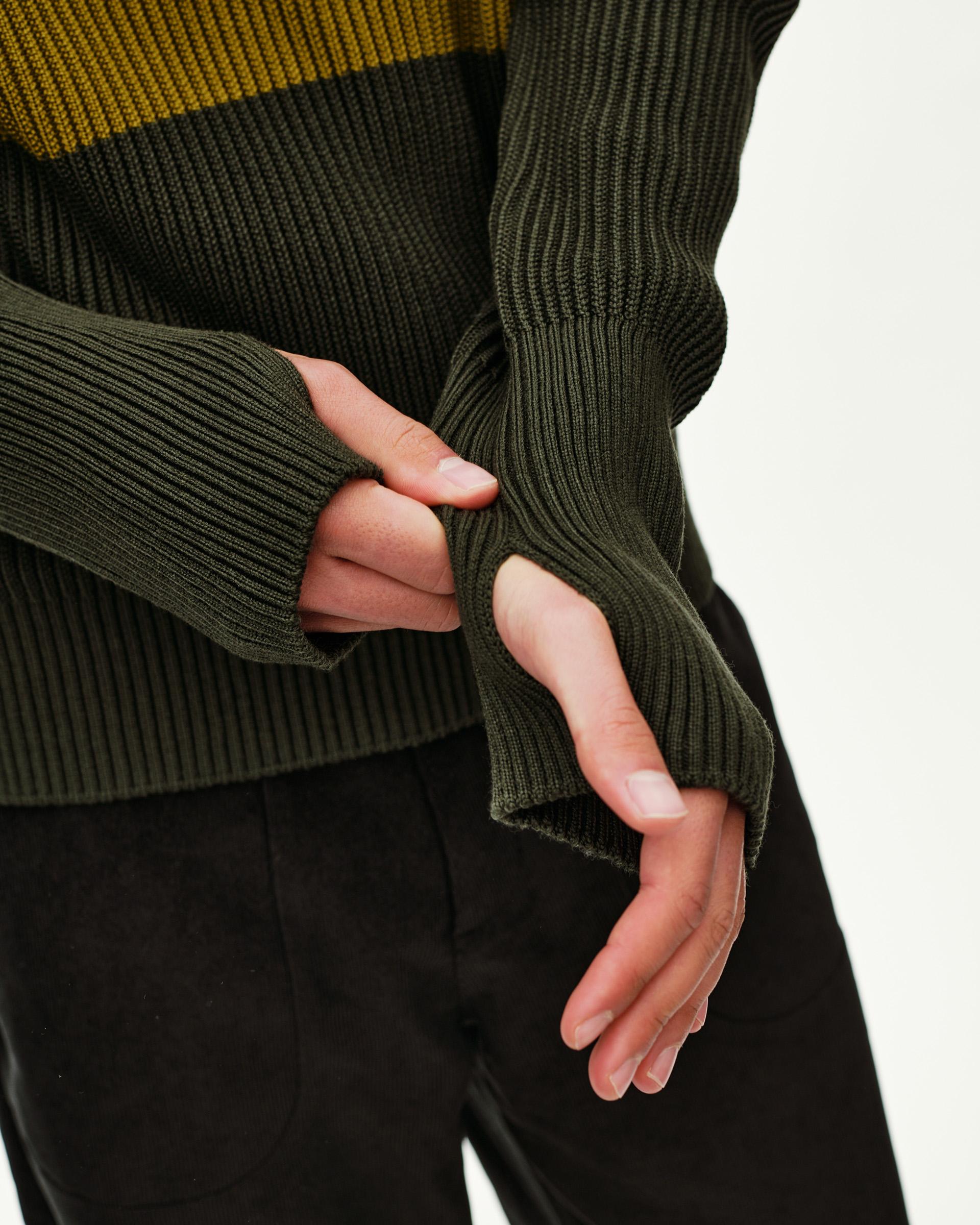Olive Off-Race Merino Knit Half-Zip sweater, detail view of ribbed cuff with thumb hole on model