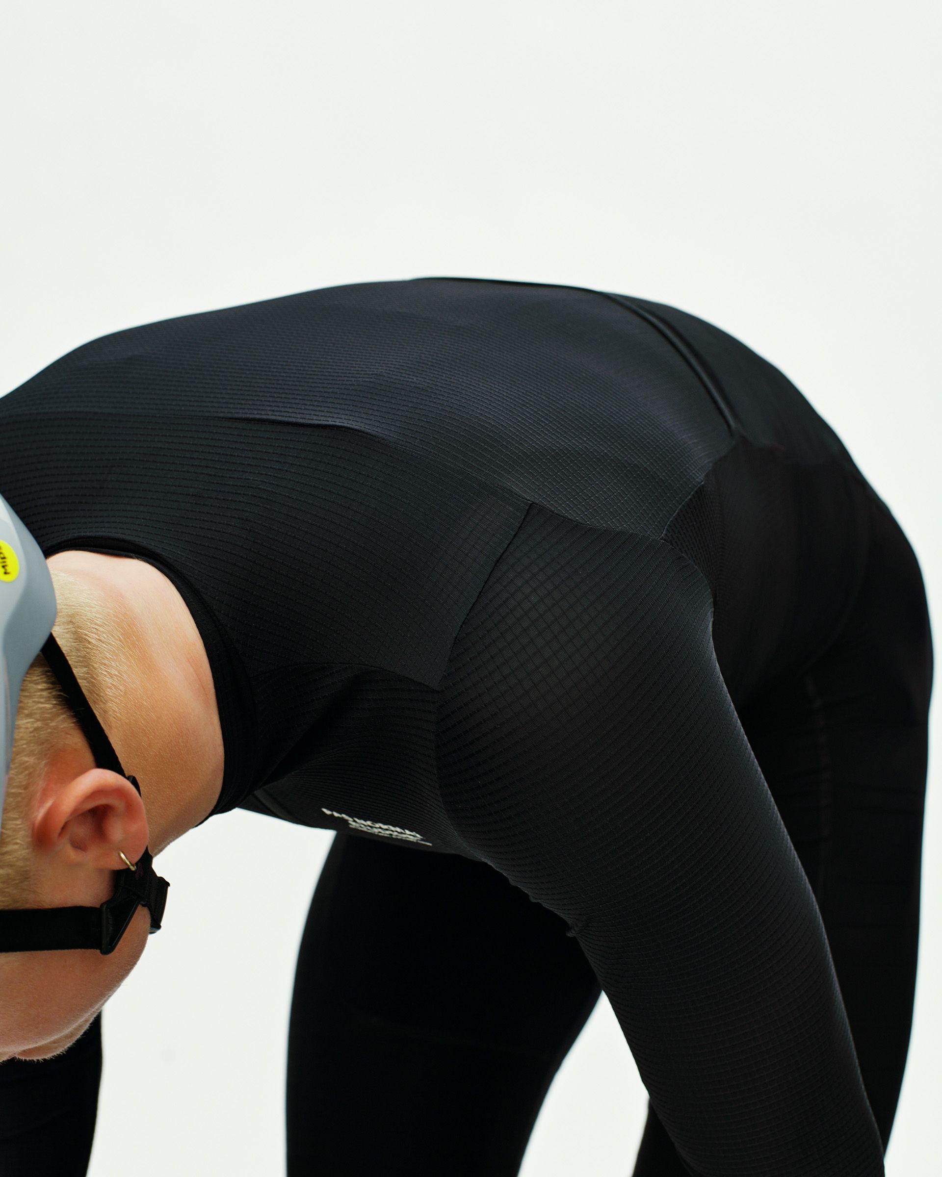 Black Mechanism Pro long sleeve cycling jersey on model in aerodynamic position with textured panels