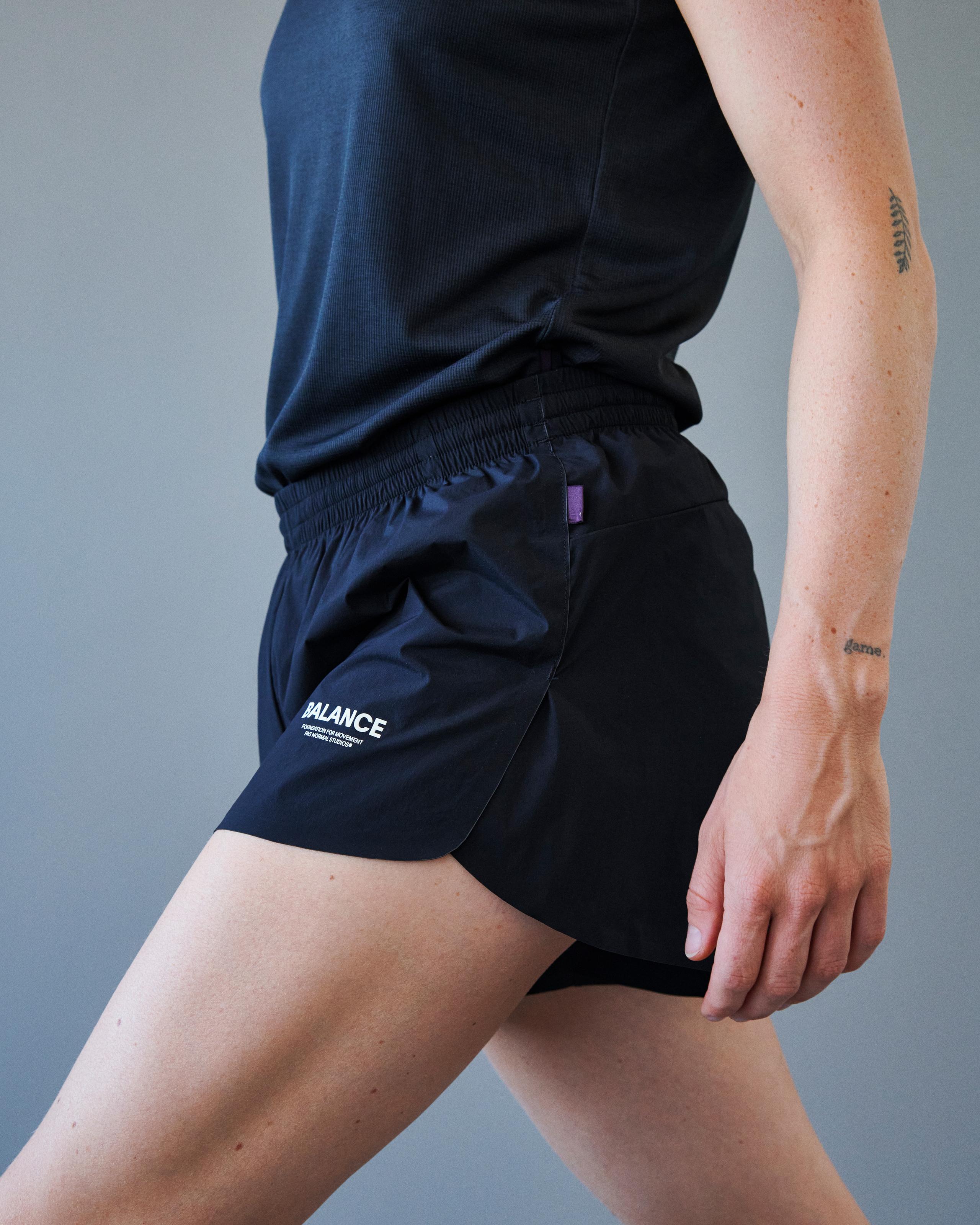 Black Balance shorts on model with elastic waistband and white leg logo