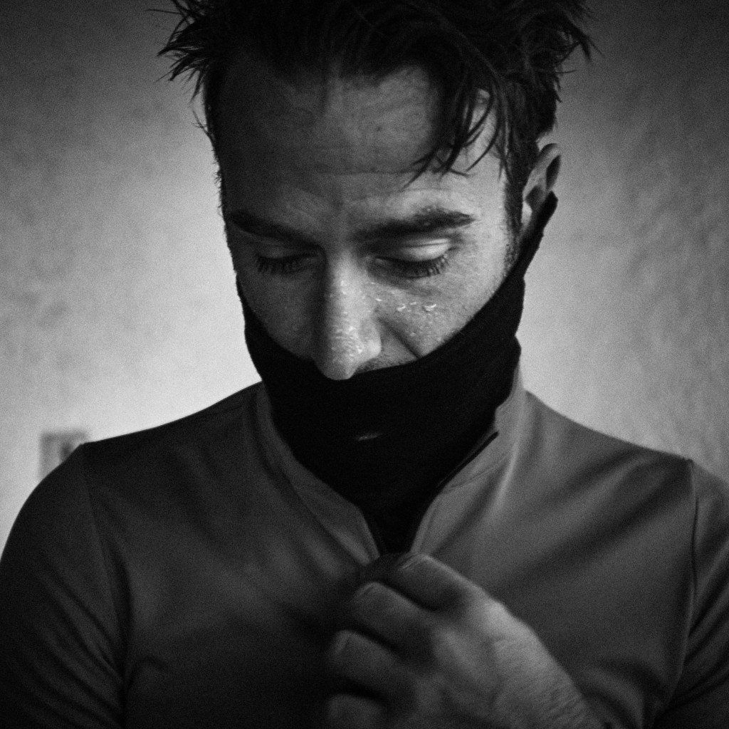 Model wearing black cycling jersey with high collar, black and white portrait