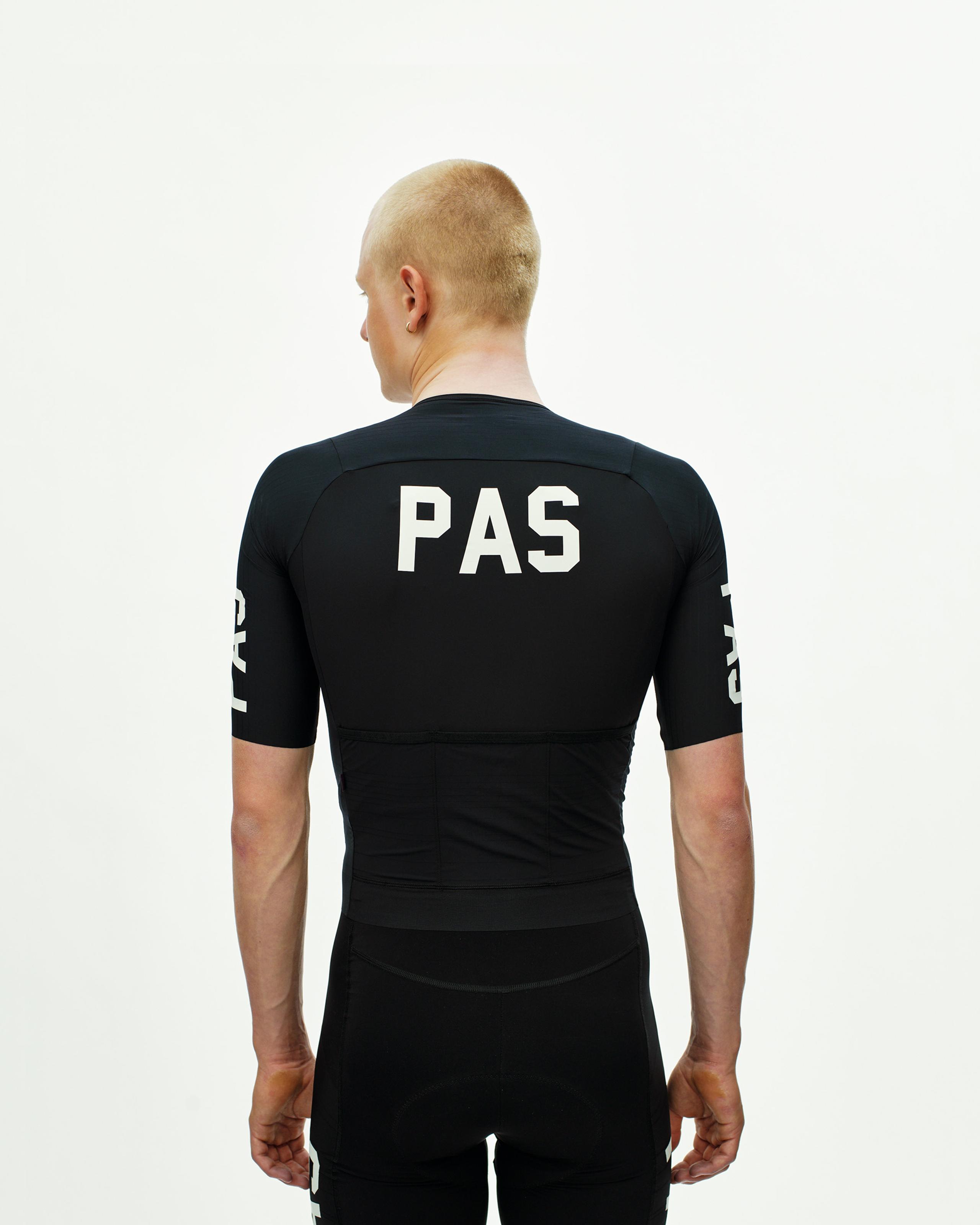Black PAS Mechanism Pro cycling jersey, rear view on model with white PAS back print and sleeve graphics
