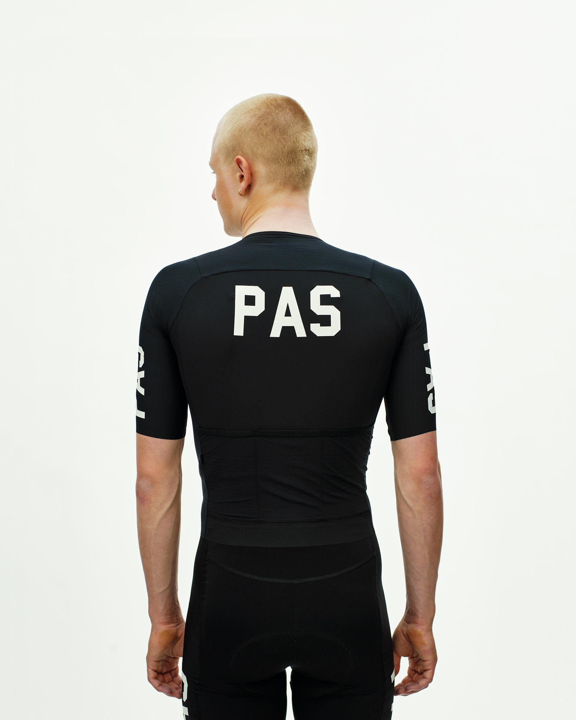 Black PAS Mechanism Pro cycling jersey, rear view on model with white PAS back print and sleeve graphics