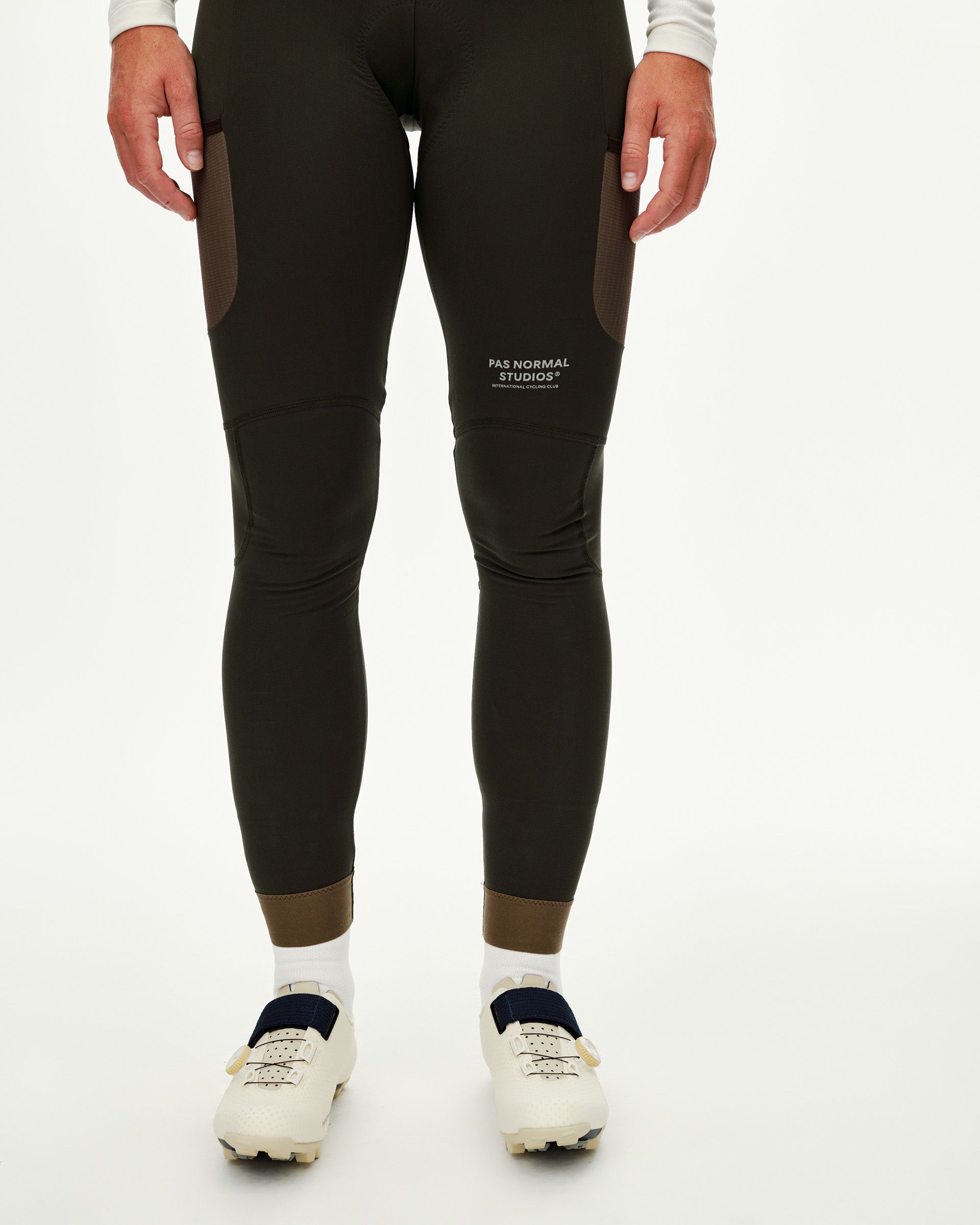 Dark Olive Escapism Long Cargo cycling bibs on model, front view with contrast panel and ribbed ankle cuff