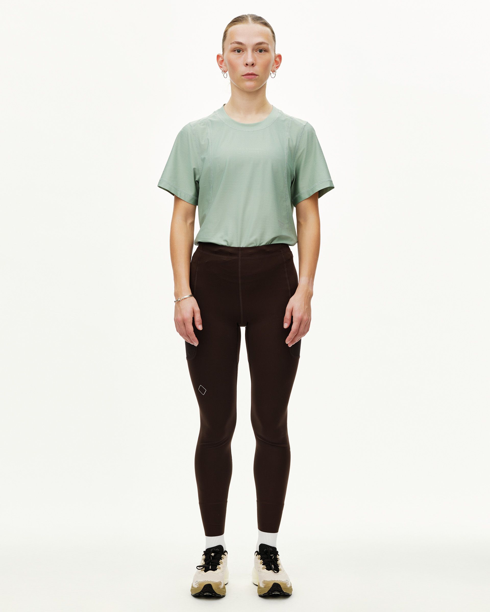 Dark Coffee Balance women's long tights on model, front view with side hip pockets and small logo patch