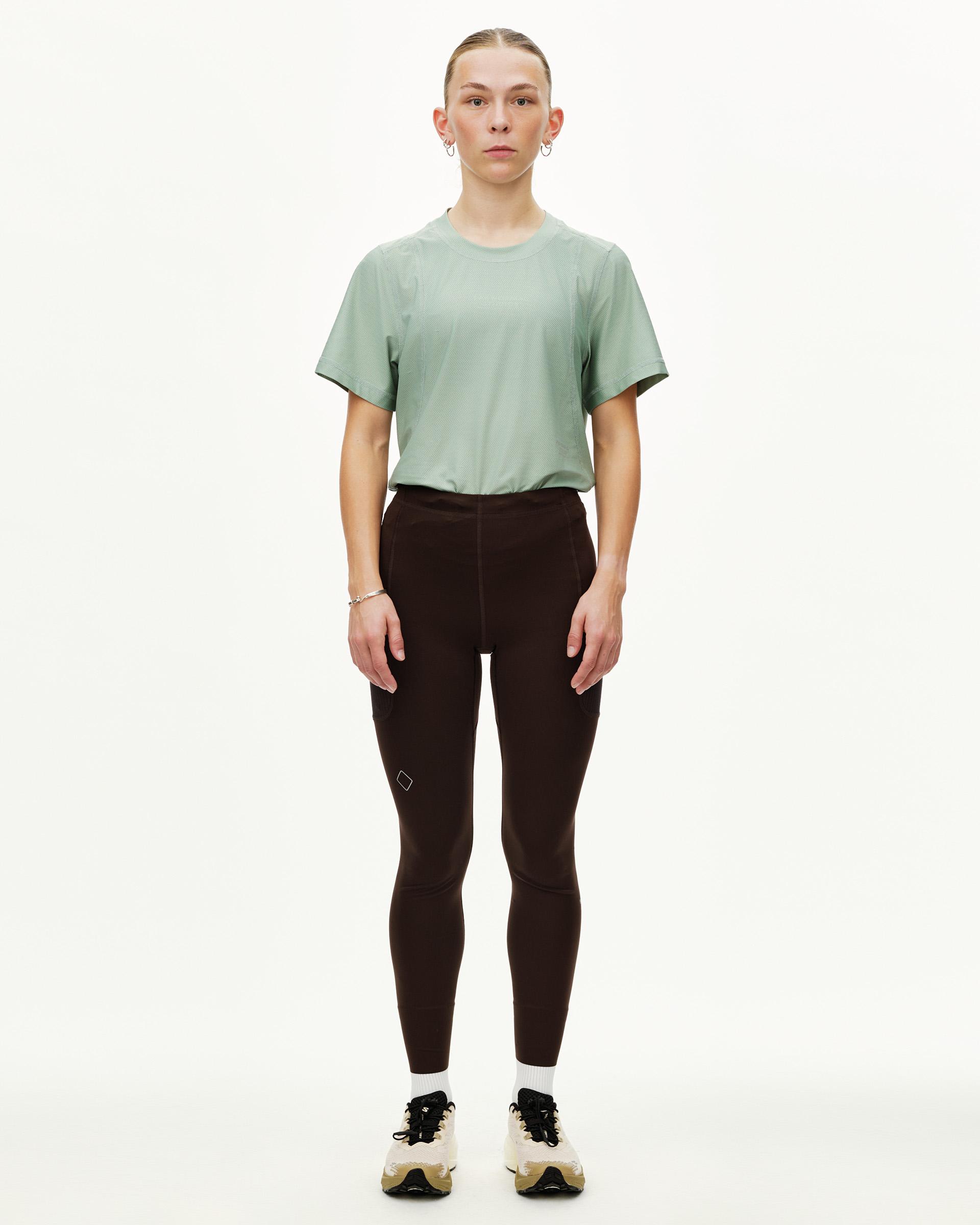 Dark Coffee Balance women's long tights on model, front view with side hip pockets and small logo patch