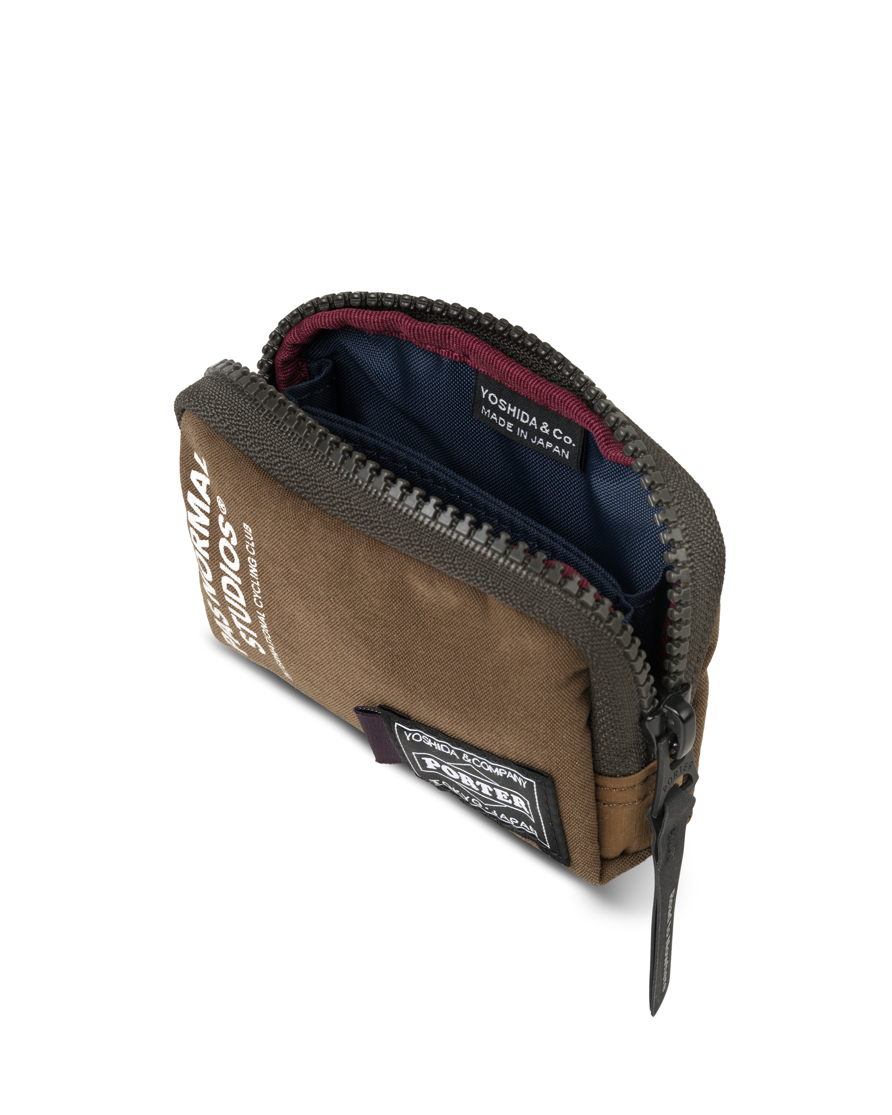 Light Brown Porter-Yoshida coin case, three-quarter view opened showing navy interior with red zip trim and woven brand patch