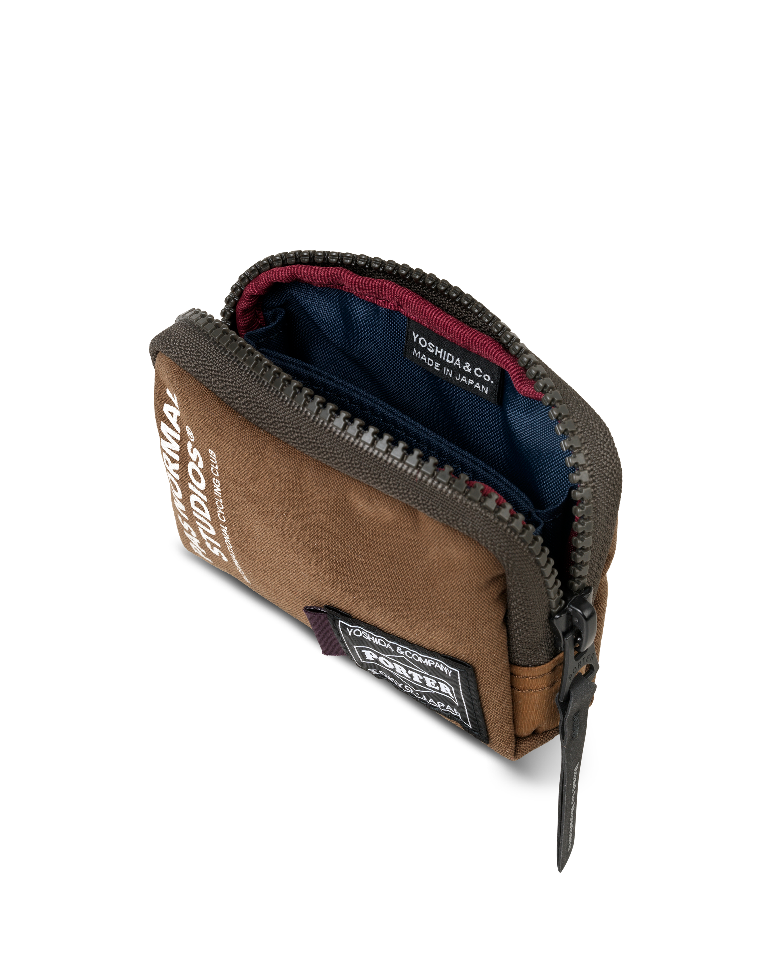 Light Brown Porter-Yoshida coin case, three-quarter view opened showing navy interior with red zip trim and woven brand patch