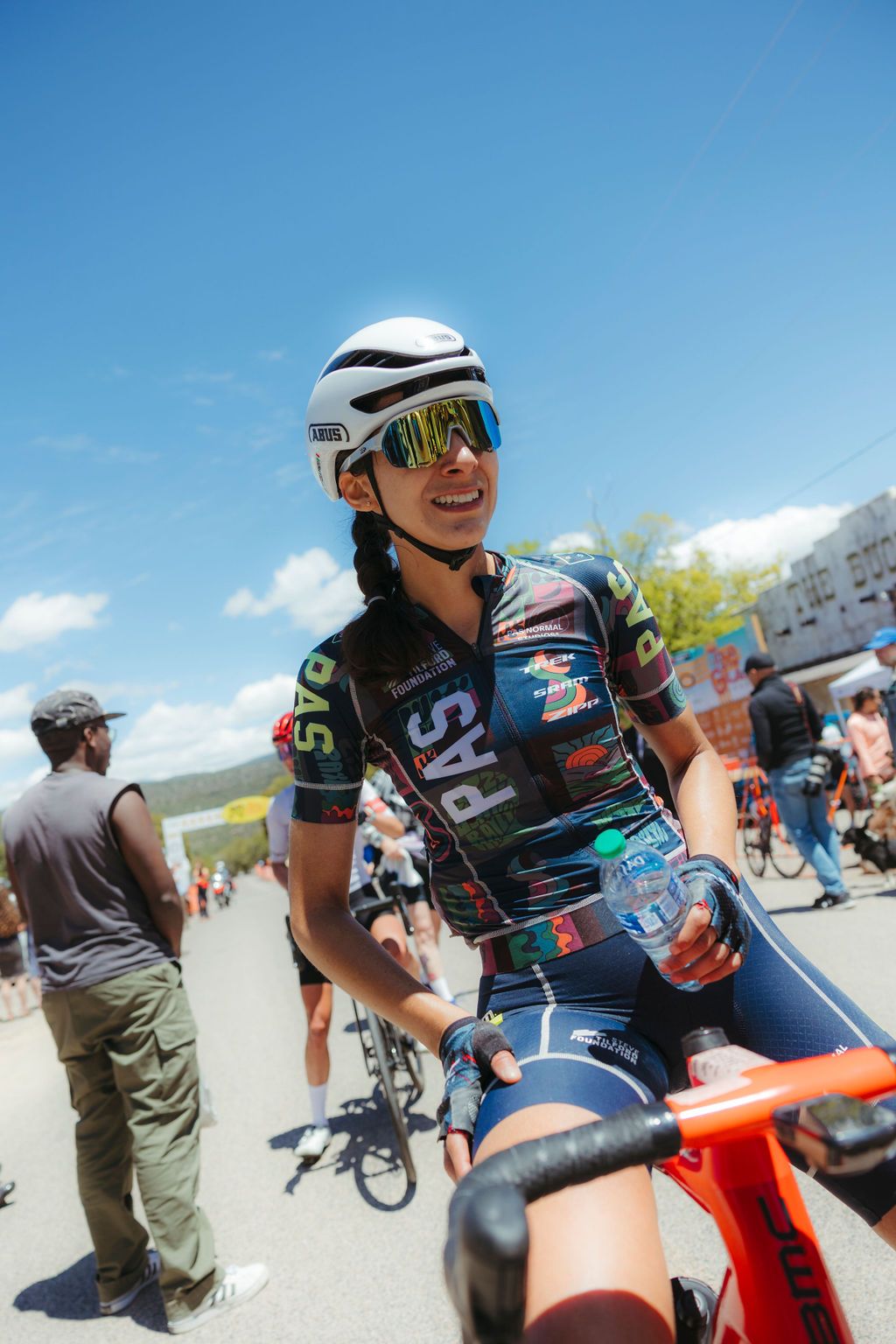Model wearing multicolored PAS collection jersey with chest lettering at cycling event
