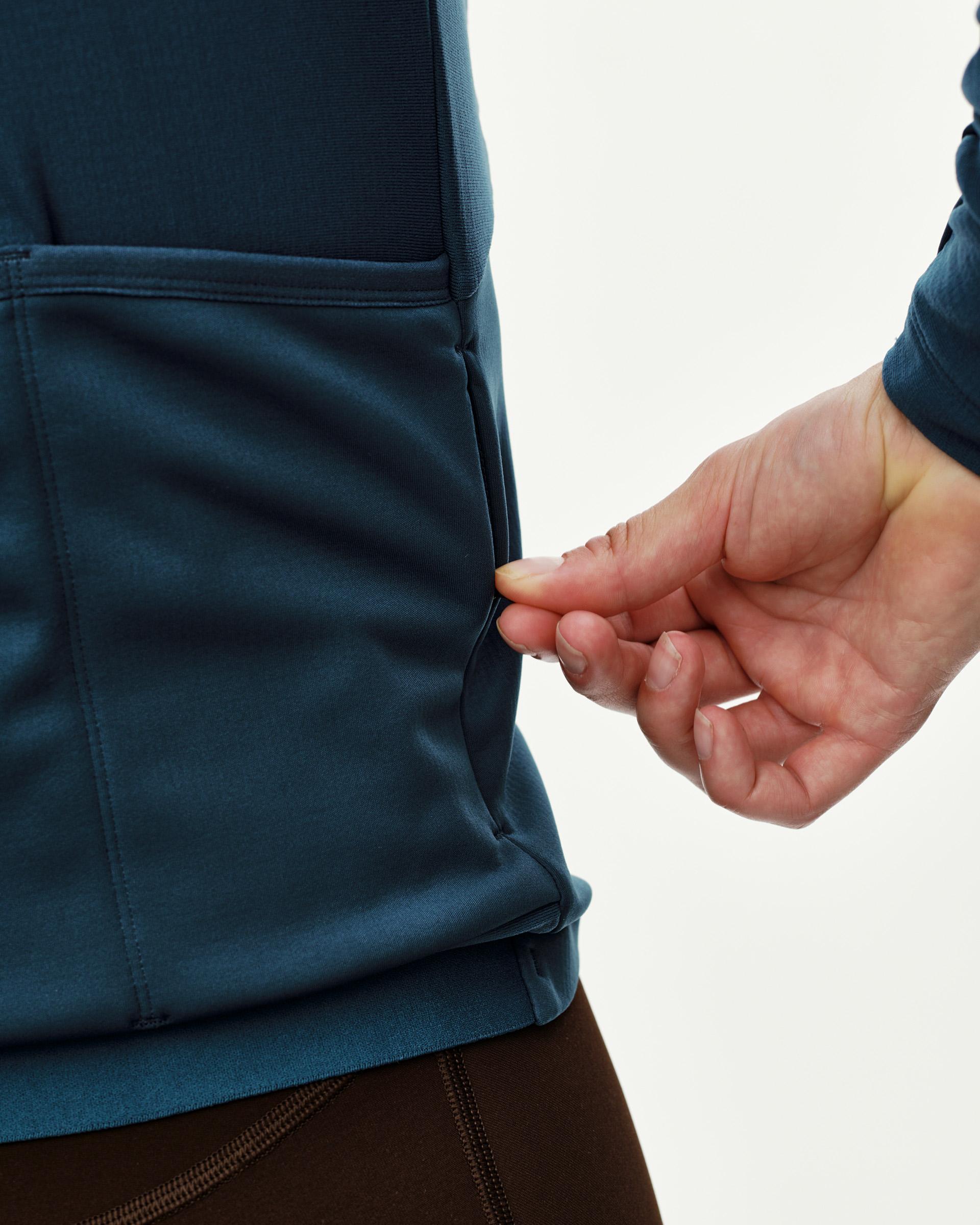 Denim Blue Mechanism Thermal Long Sleeve cycling jersey, side detail on model showing rear pocket opening