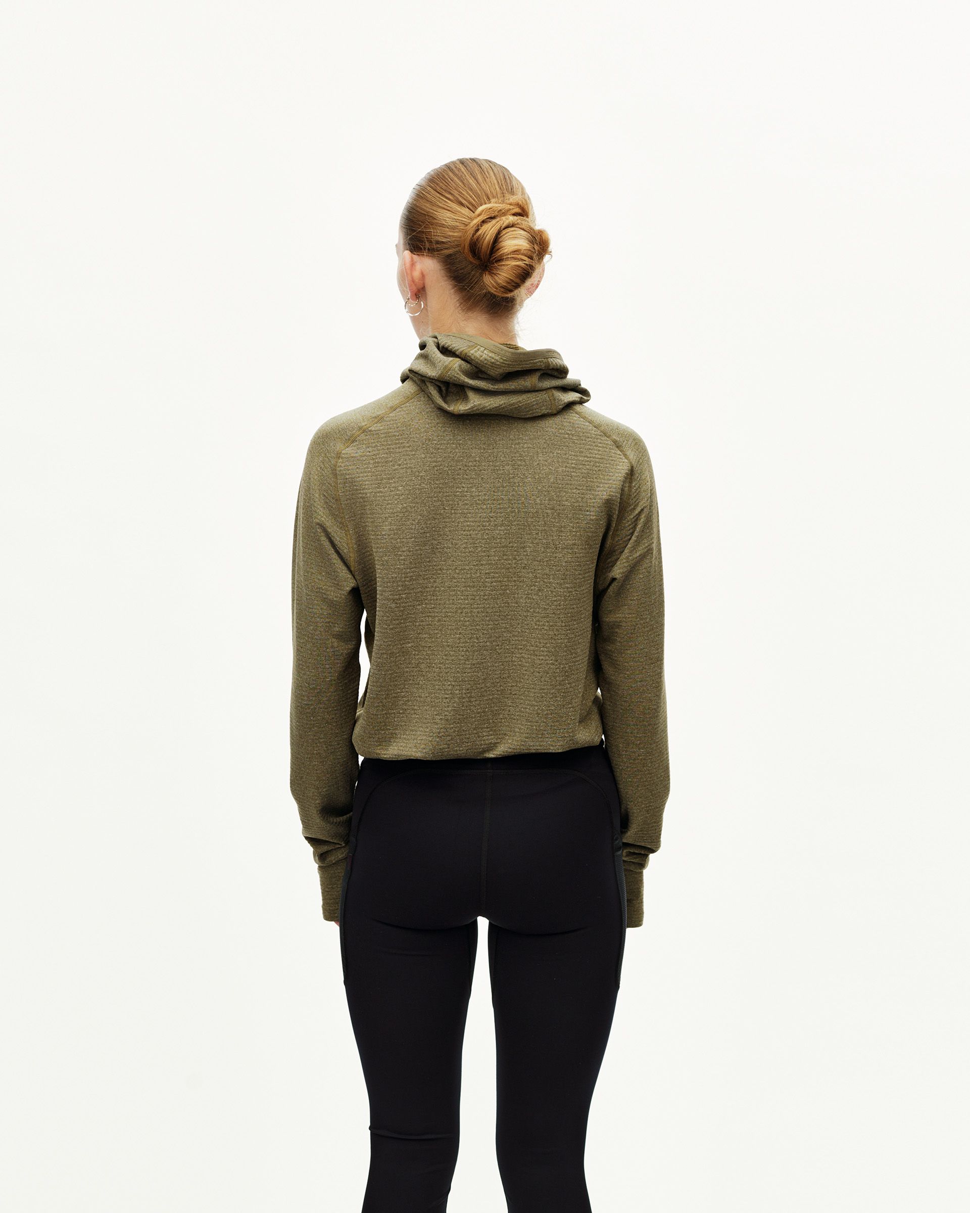 Black Balance long tights, rear view on model with olive hoodie layered over