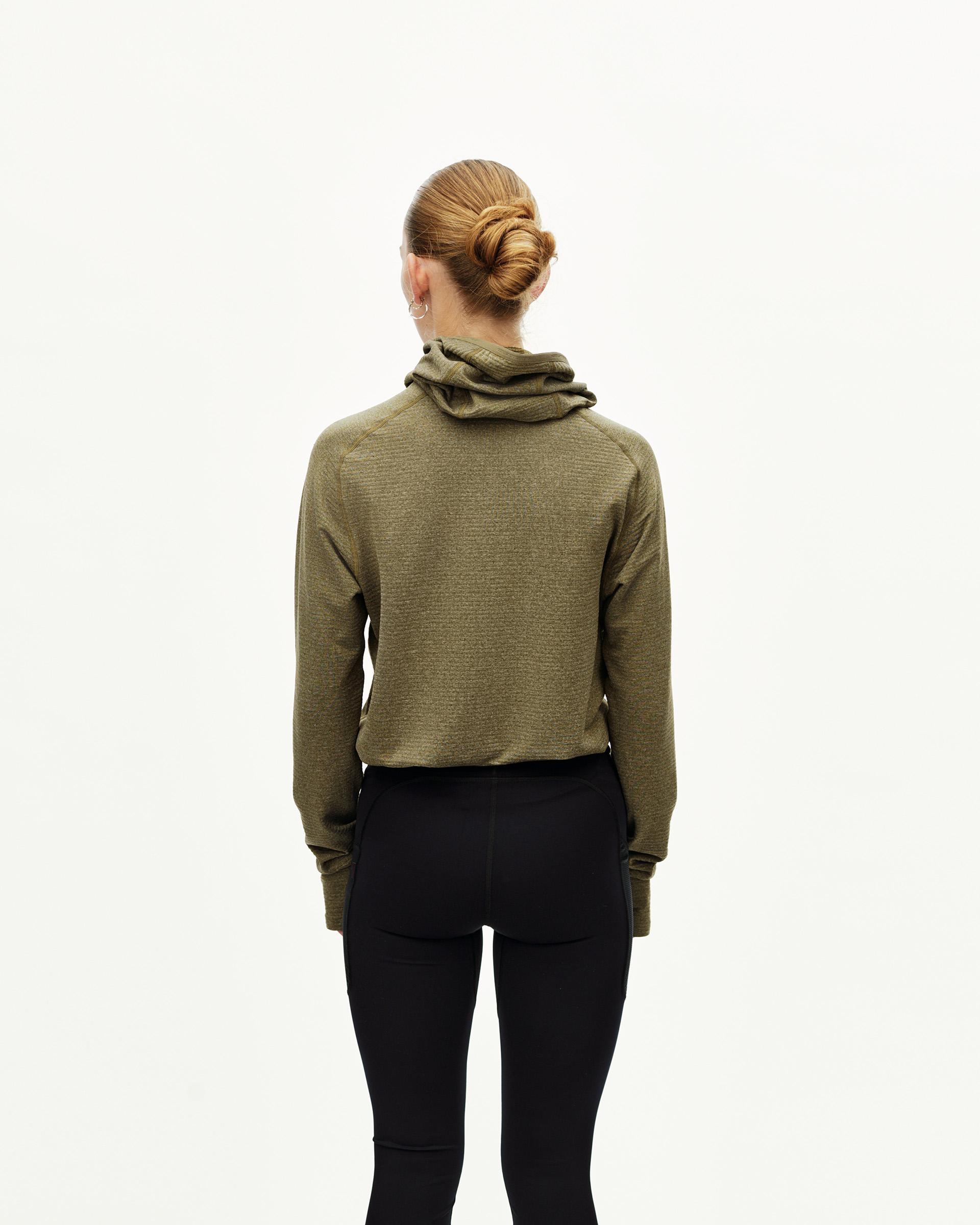 Black Balance long tights, rear view on model with olive hoodie layered over