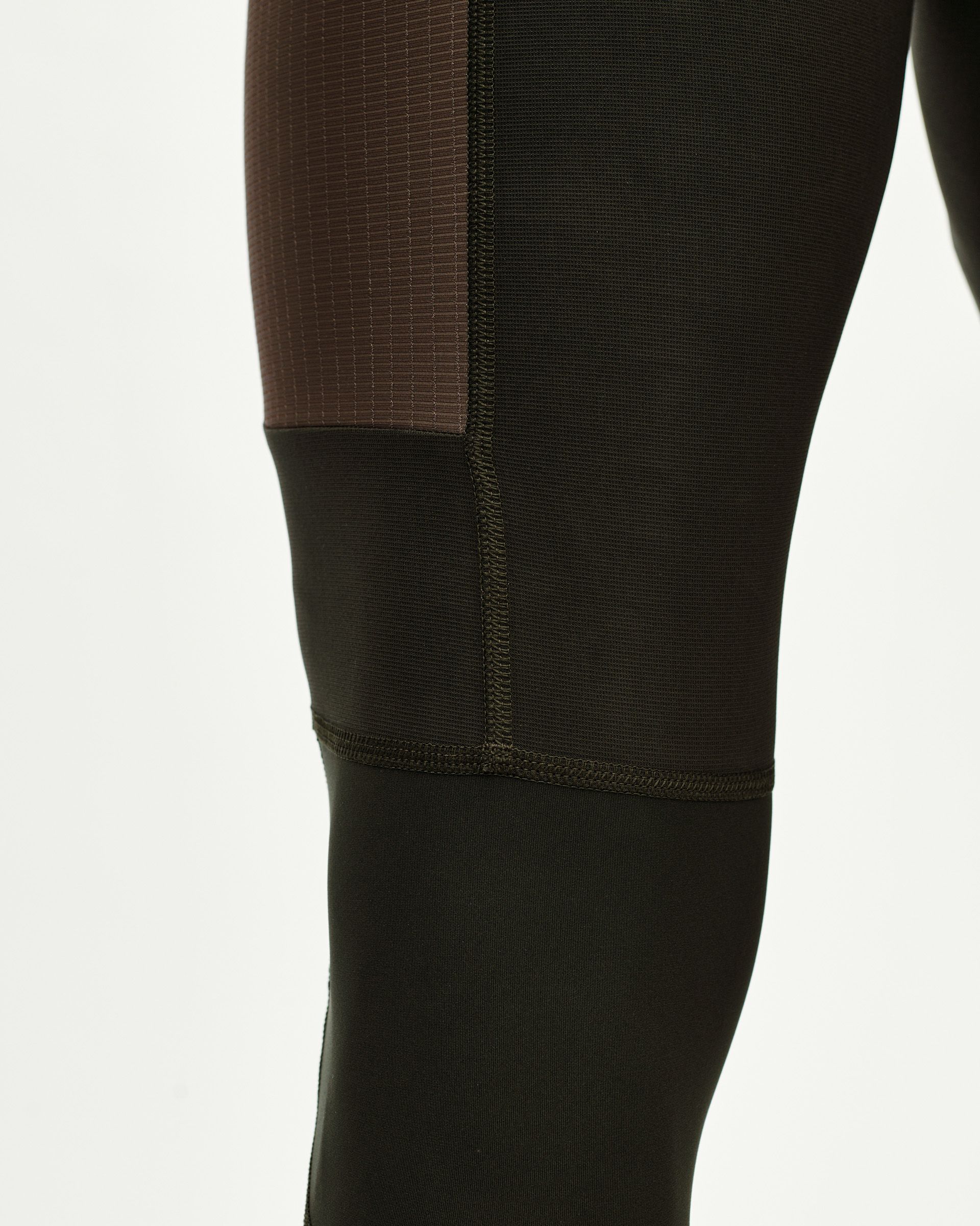 Dark Olive Escapism Long Cargo cycling bibs, side detail on model with contrast ribbed upper panel