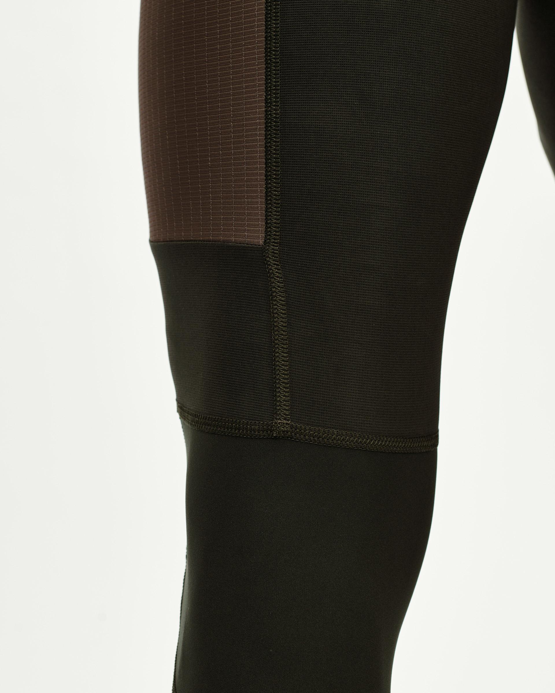 Dark Olive Escapism Long Cargo cycling bibs, side detail on model with contrast ribbed upper panel