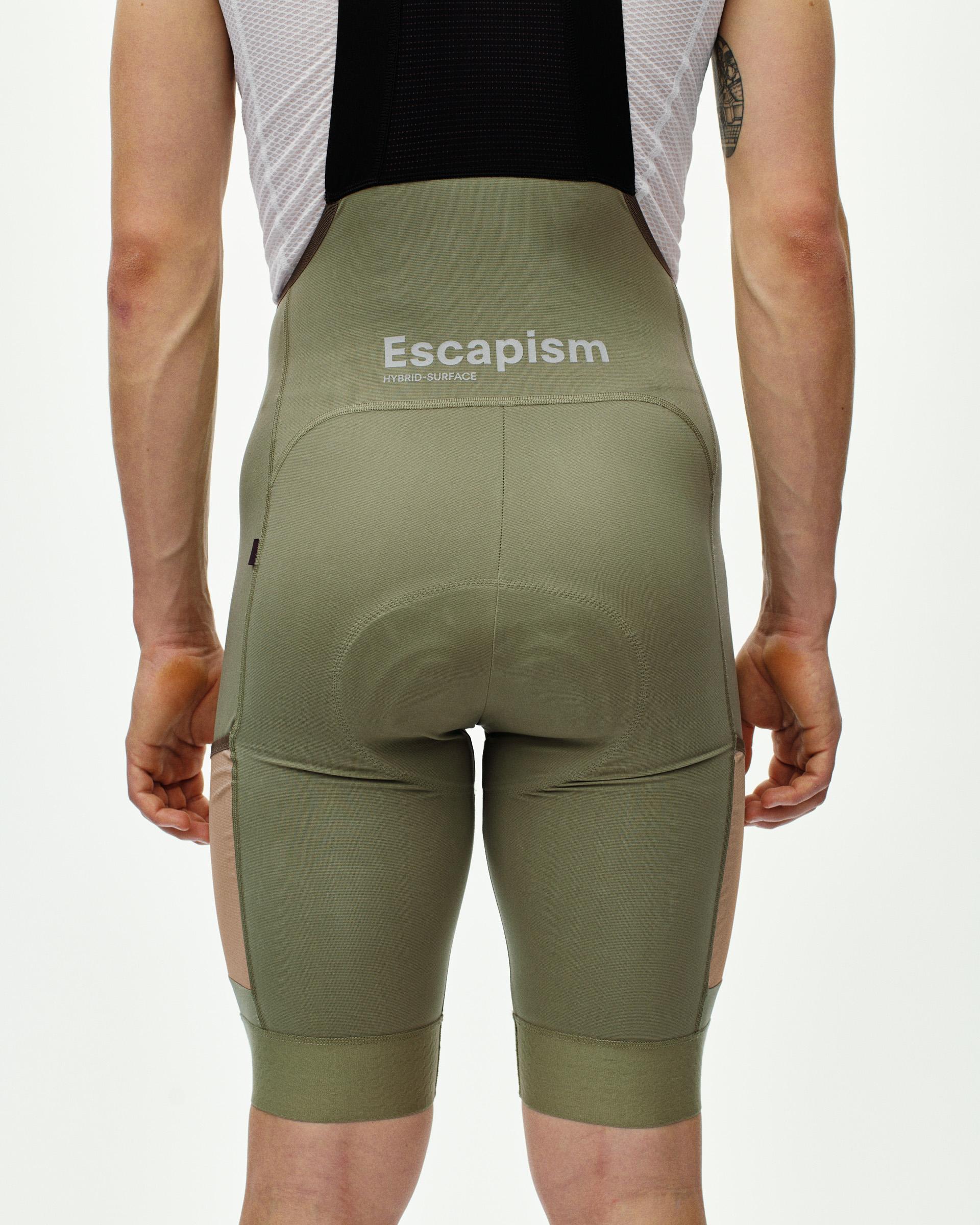 Light Olive Escapism cargo bibs, rear view on model with white chest logo print