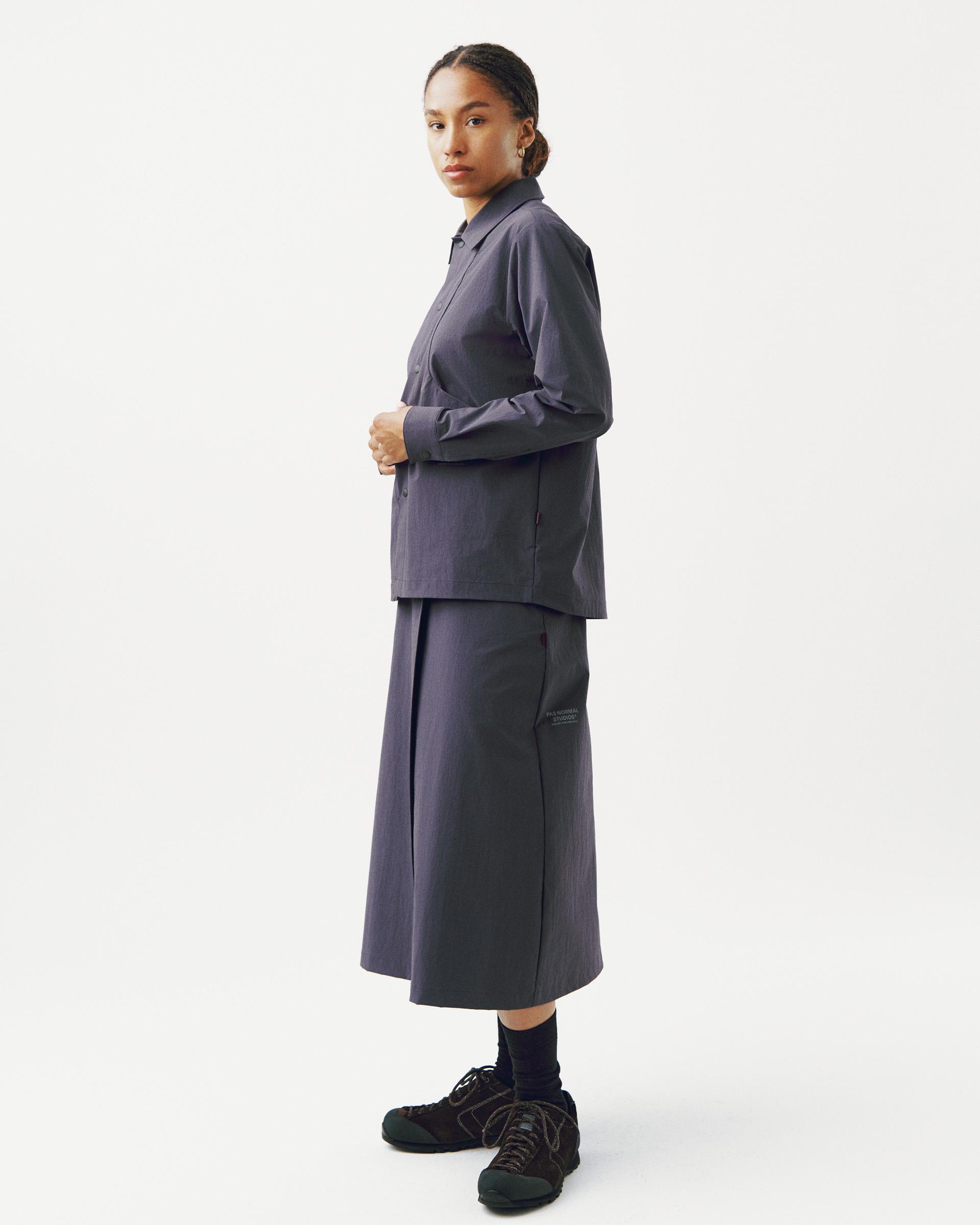 Grey Off-Race Tech skirt on model, side view with midi length and zippered side panel