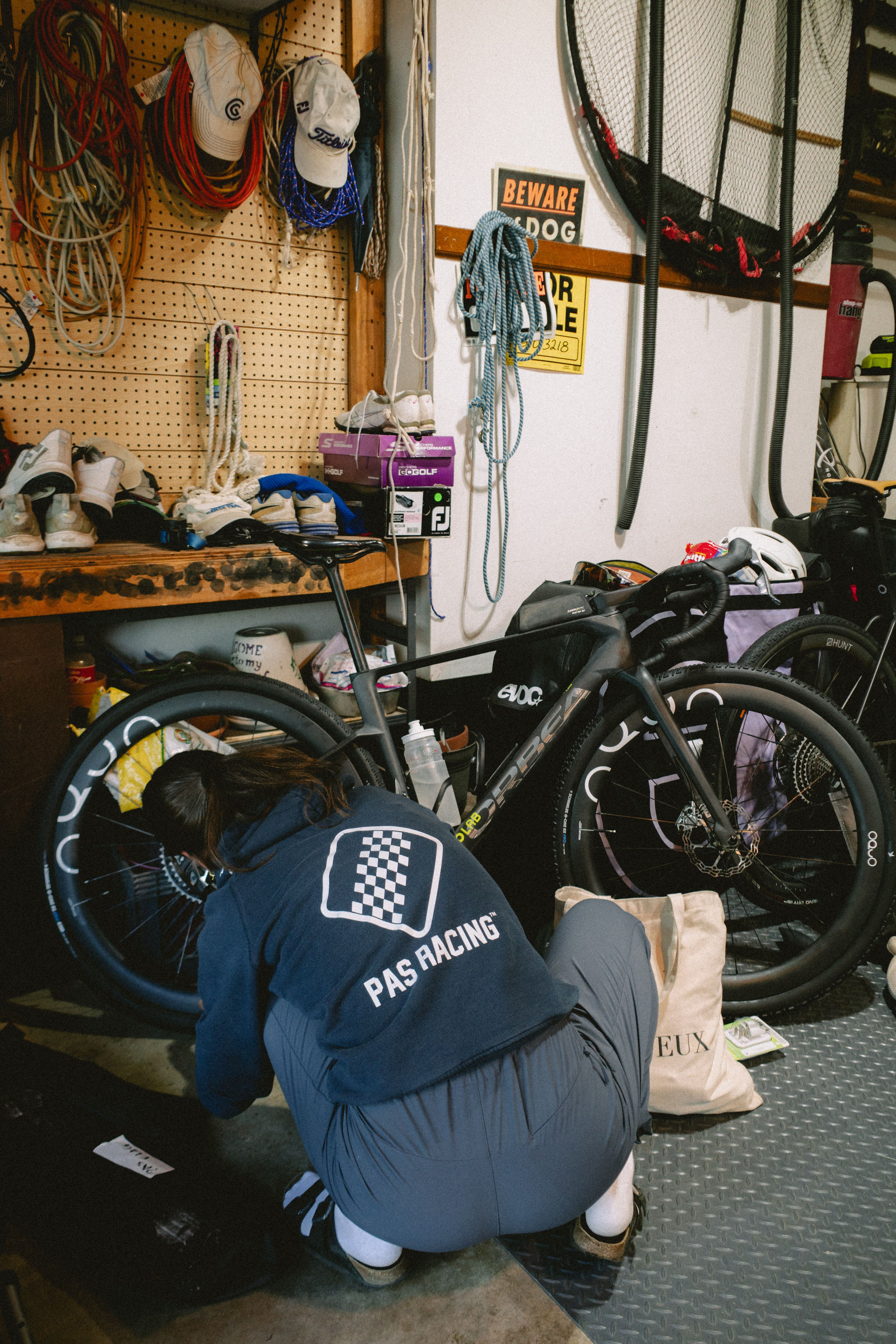 Cyclist in blue racing jersey working on bike in garage workshop