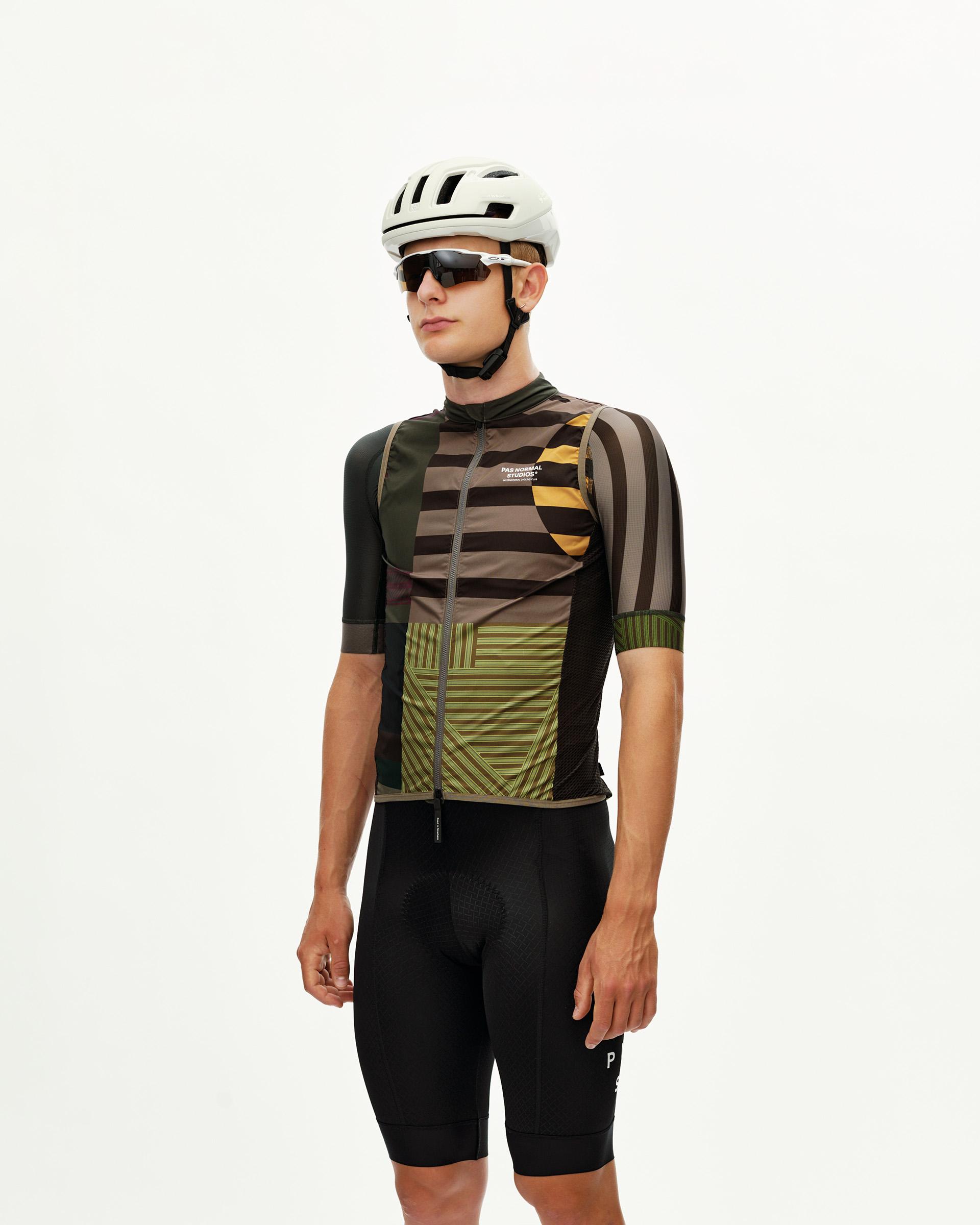 International Earth Mechanism Stow Away cycling gilet on model, front three-quarter view with geometric stripe print