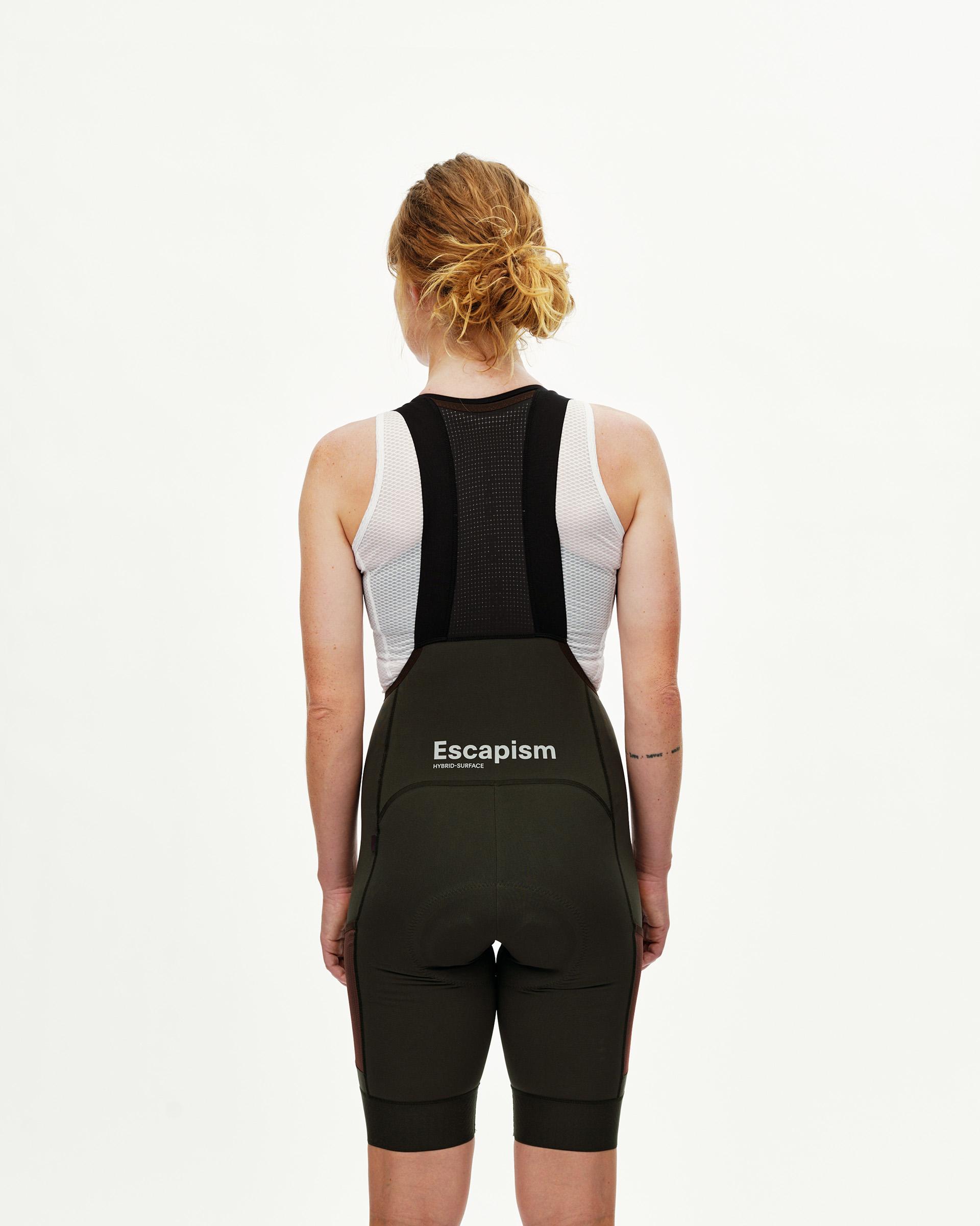 Dark Olive Escapism Cargo cycling bibs on model, rear view with white logo print and black mesh back panel