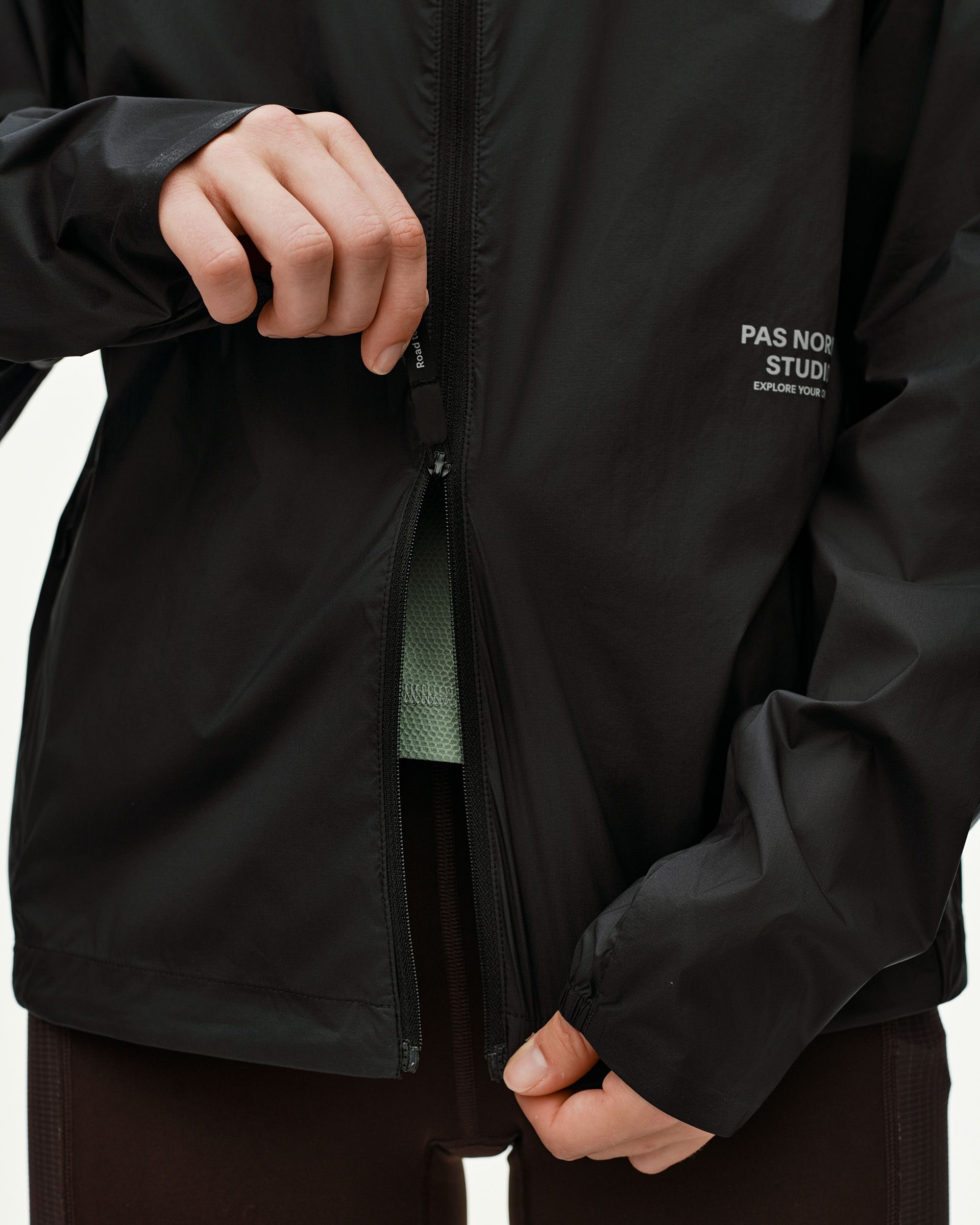 Black Balance Windproof jacket, front detail on model with open chest zip pocket