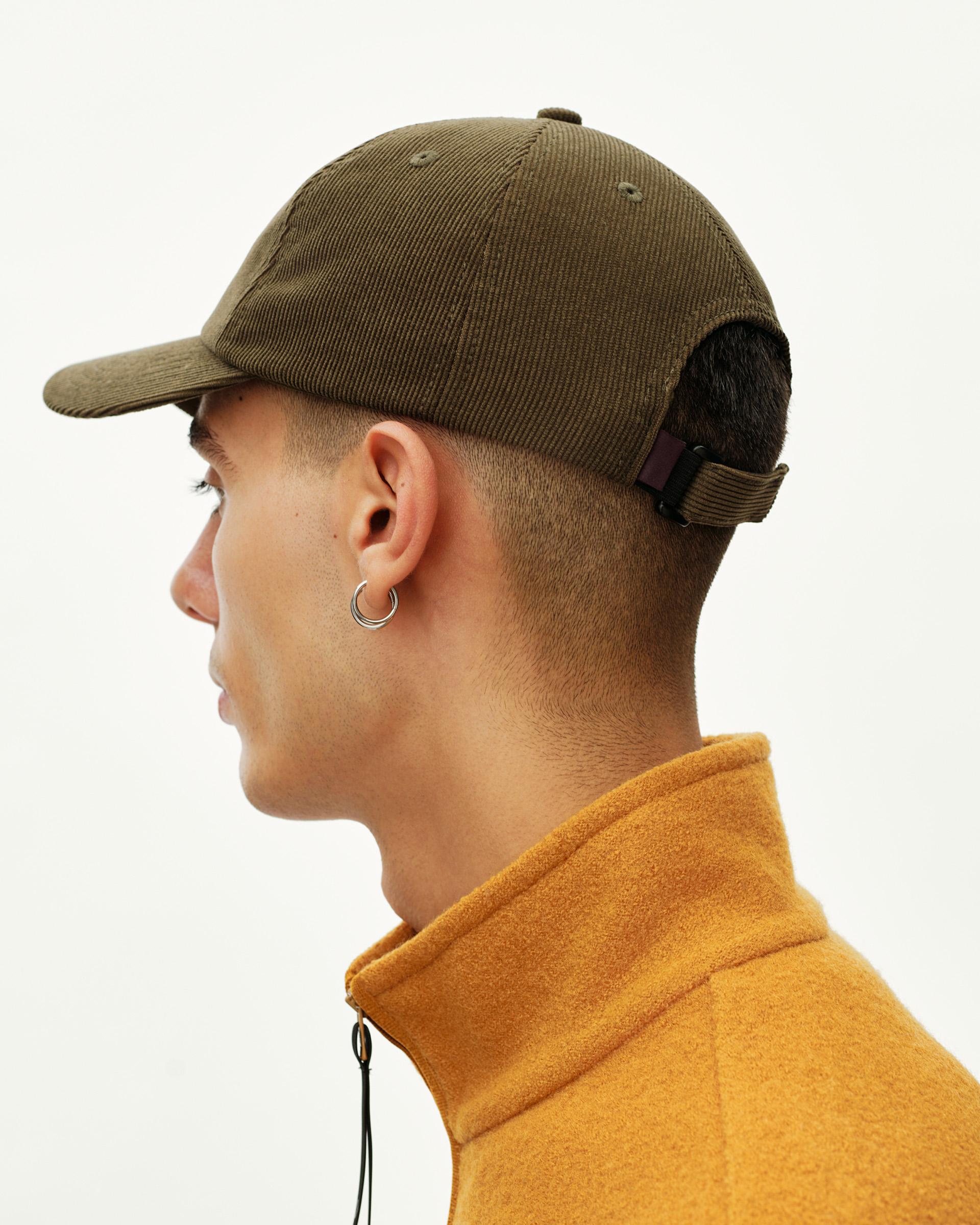 Deep Olive Off-Race Tech Corduroy cap on model, side view showing corduroy texture and adjustable back strap