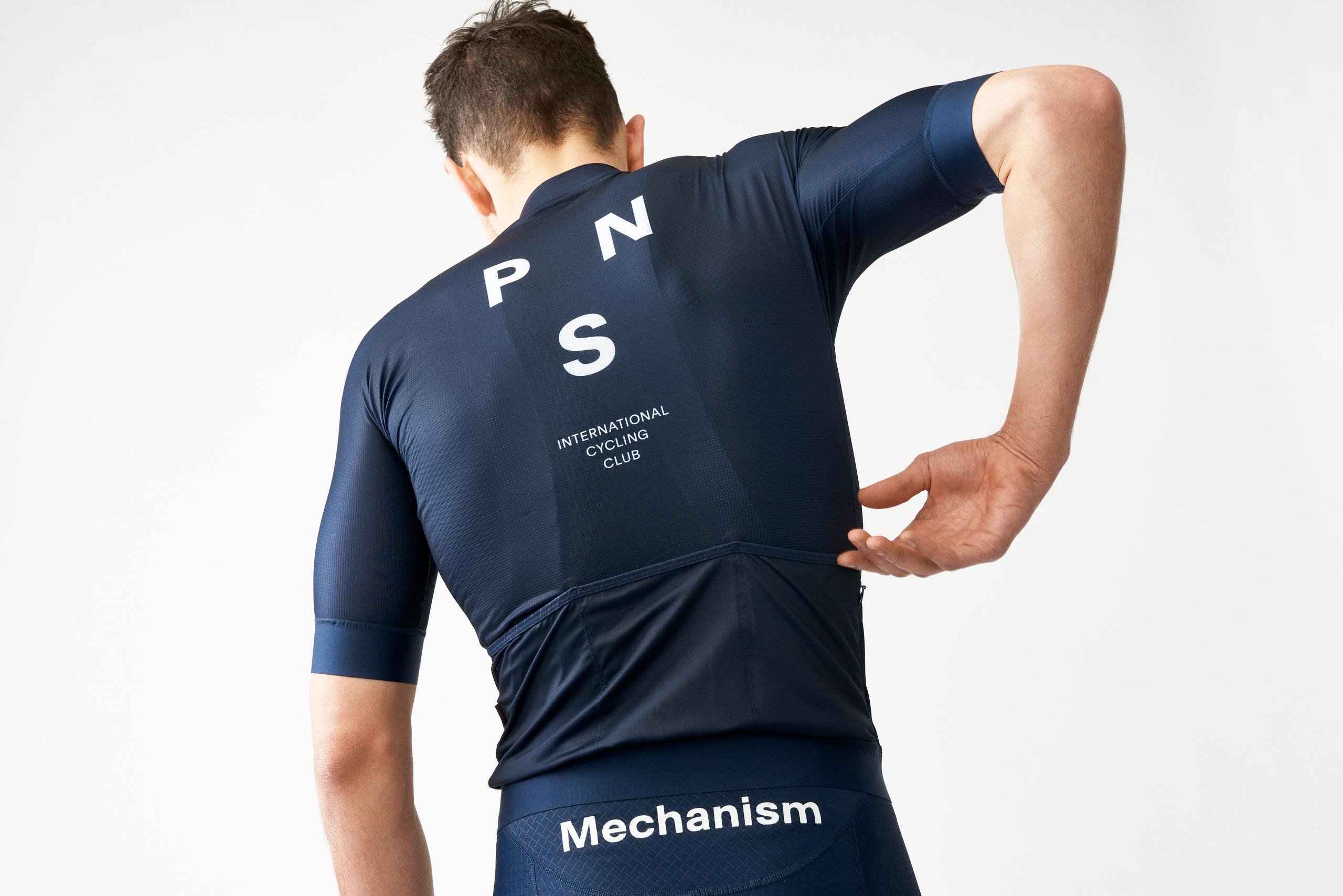 Navy Mechanism cycling jersey on model, rear view with white PNS logo and International Cycling Club text