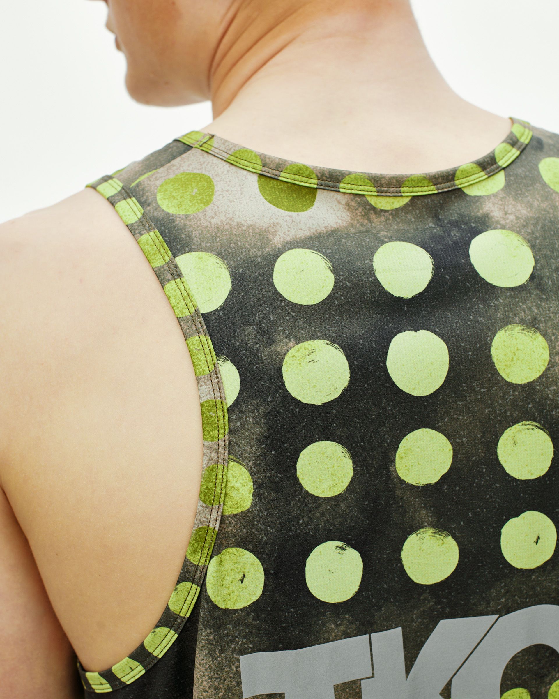 Green T.K.O. Balance singlet on model, rear view with lime green polka dot print