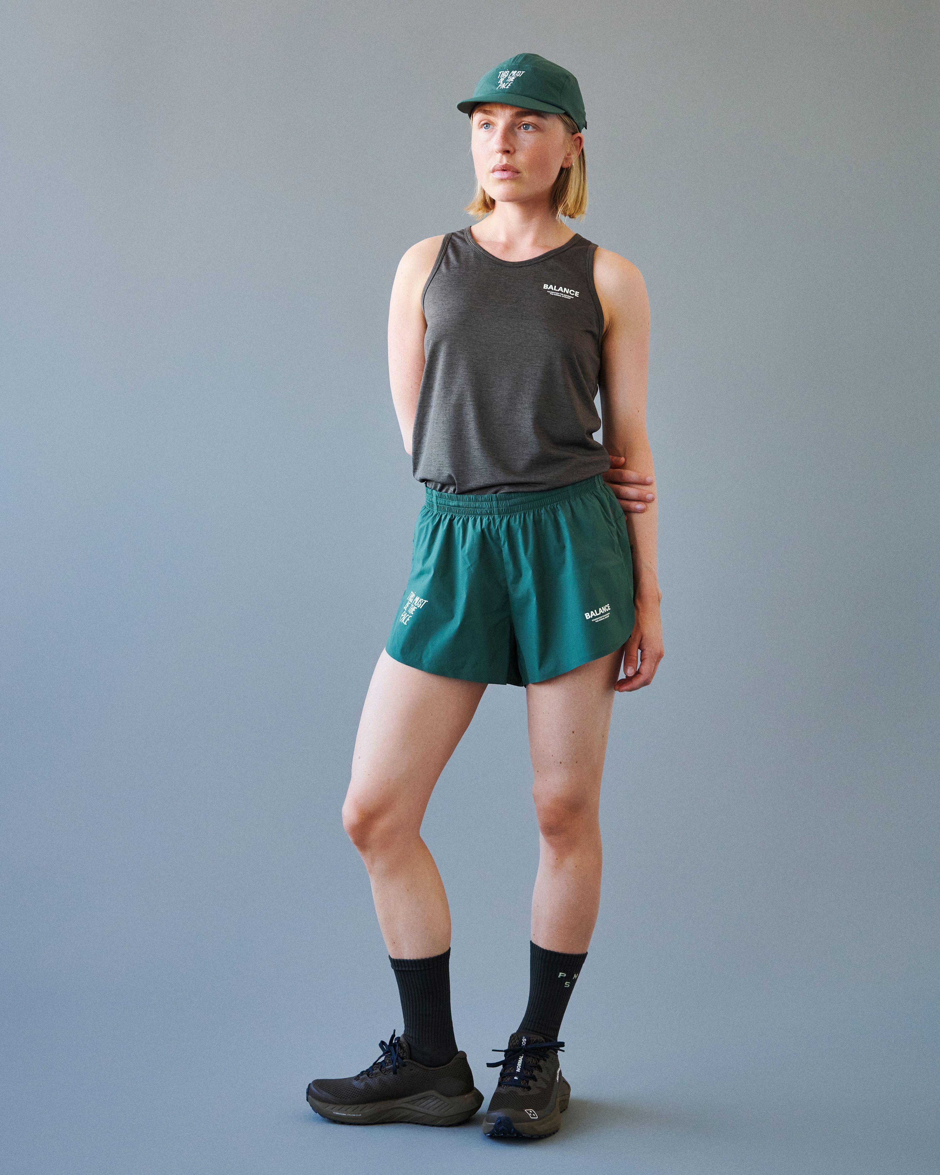 Forest Green Balance shorts on model, front view with elastic waistband and white chest logo print