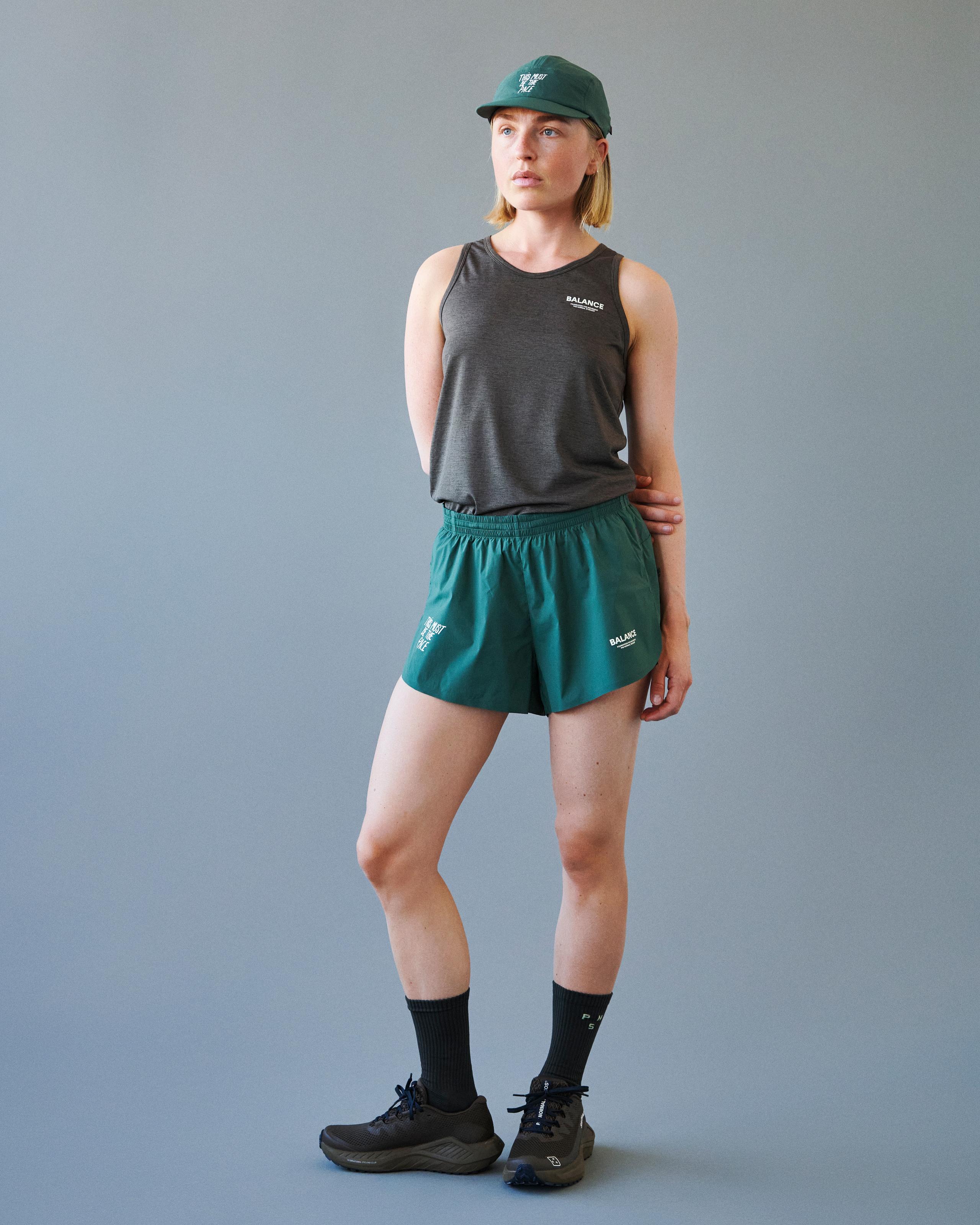 Forest Green Balance shorts on model, front view with elastic waistband and white chest logo print