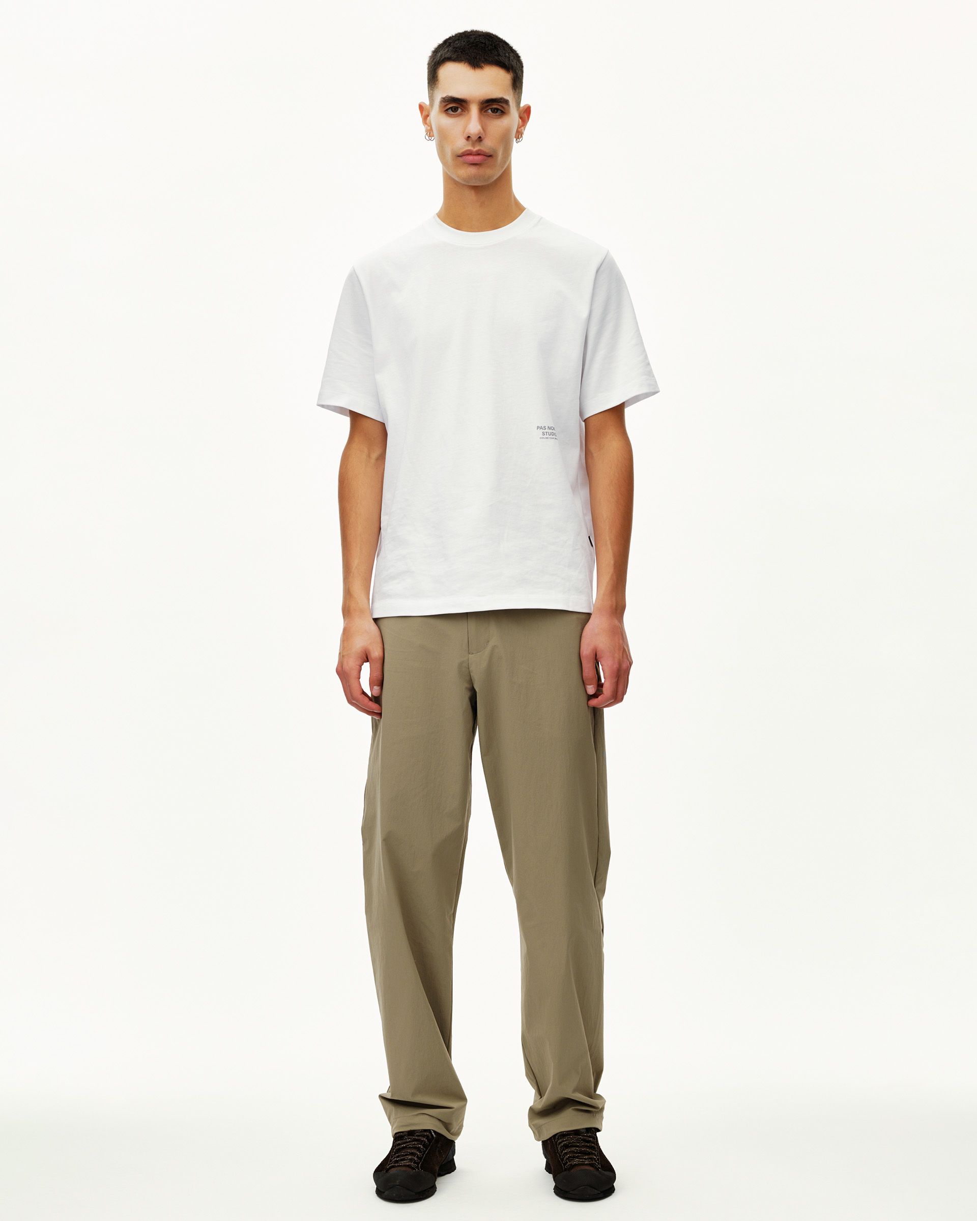 Khaki Green Off-Race Tech pants on model, front view with relaxed straight leg fit