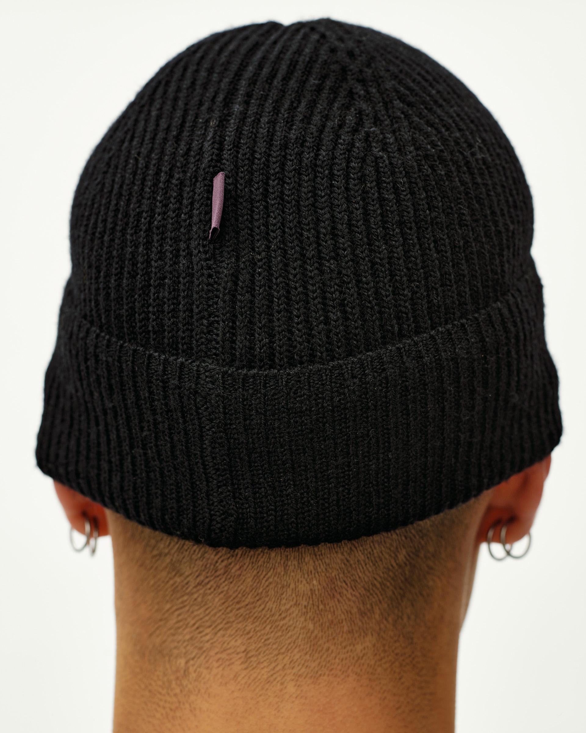 Black Off-Race Merino Knit Beanie on model, rear view with ribbed knit and folded cuff