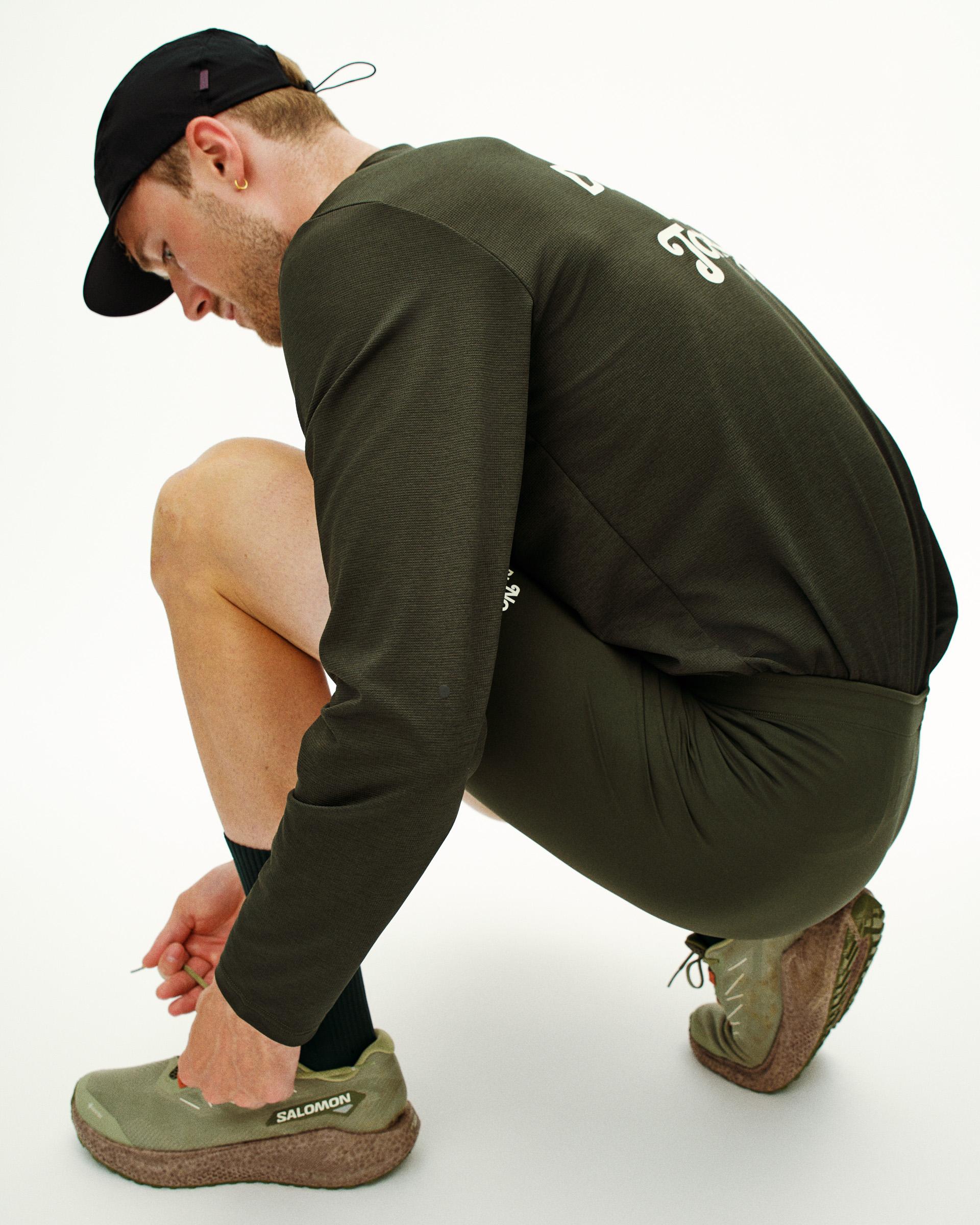 Dark Olive Balance short tights on model in crouched position with drawstring waistband