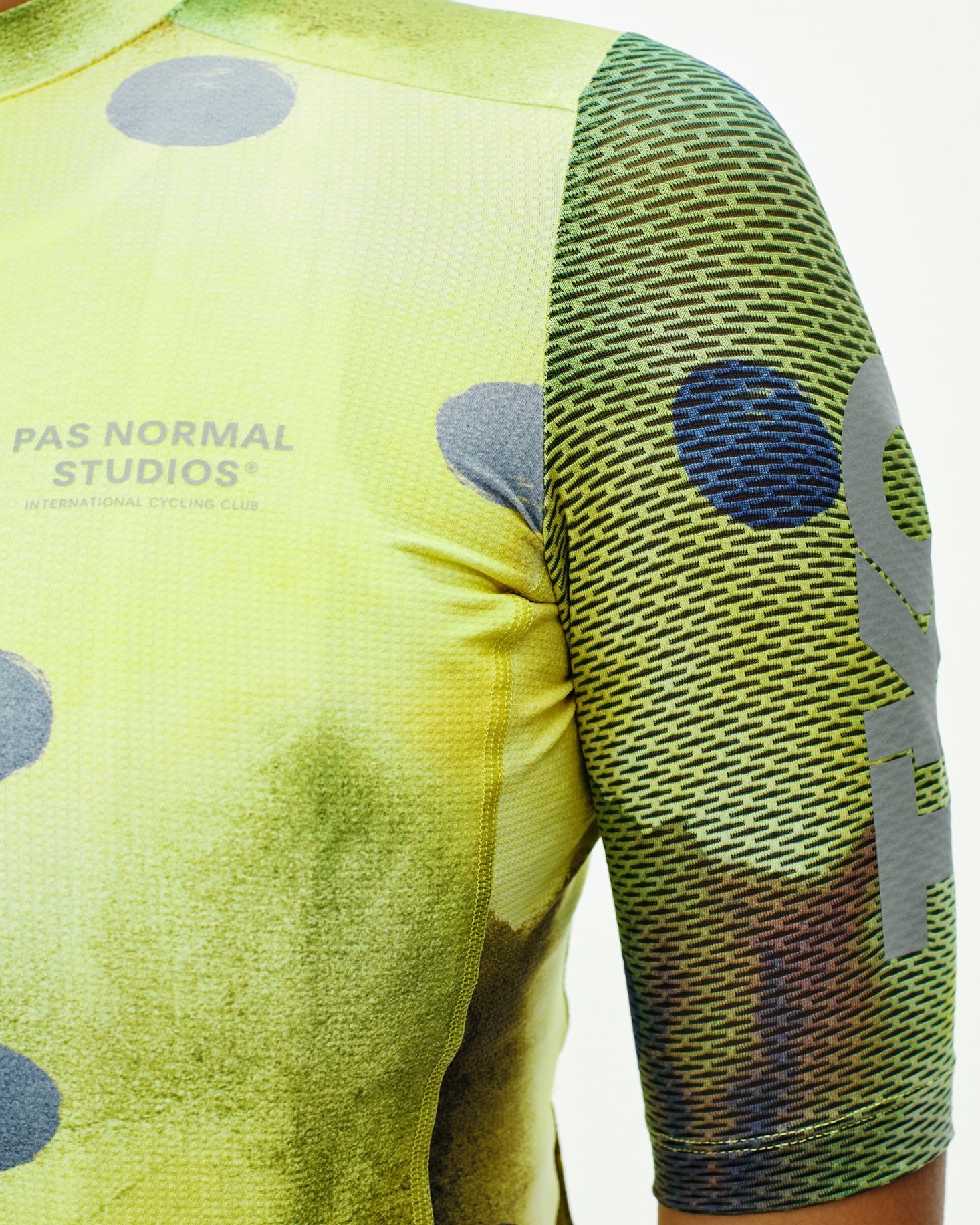 Yellow T.K.O. Essential Light cycling jersey on model with grey polka dots and multicolor sleeve detail