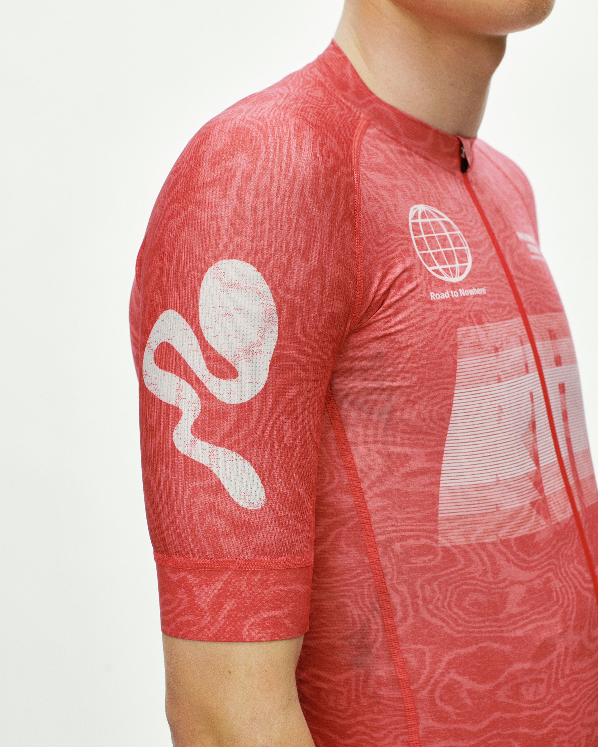 Red Mechanism cycling jersey on model, three-quarter front view with topo print and white globe graphic on chest