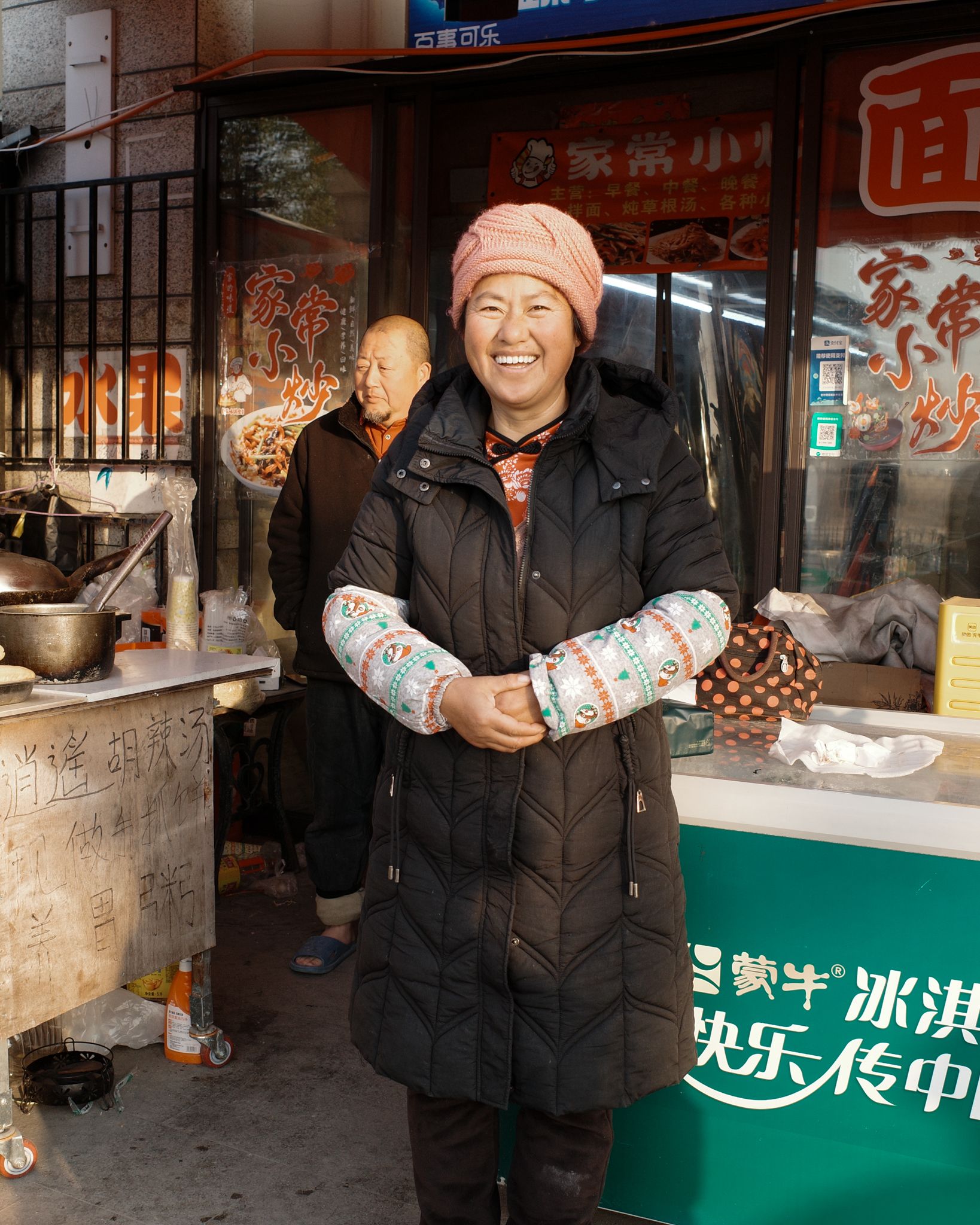Model wearing winter outerwear at street food stall