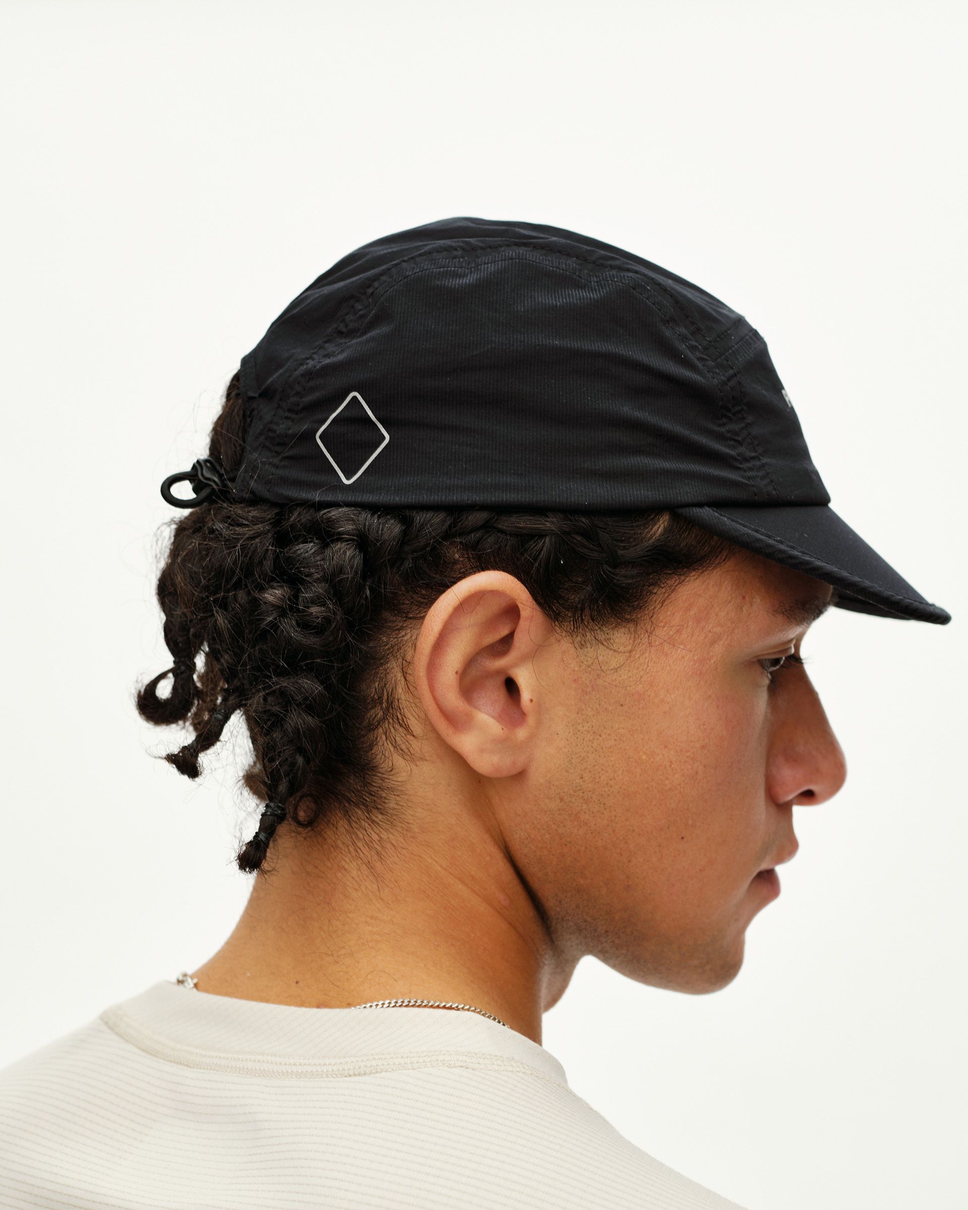 Black Balance cap, side view on model with diamond logo badge