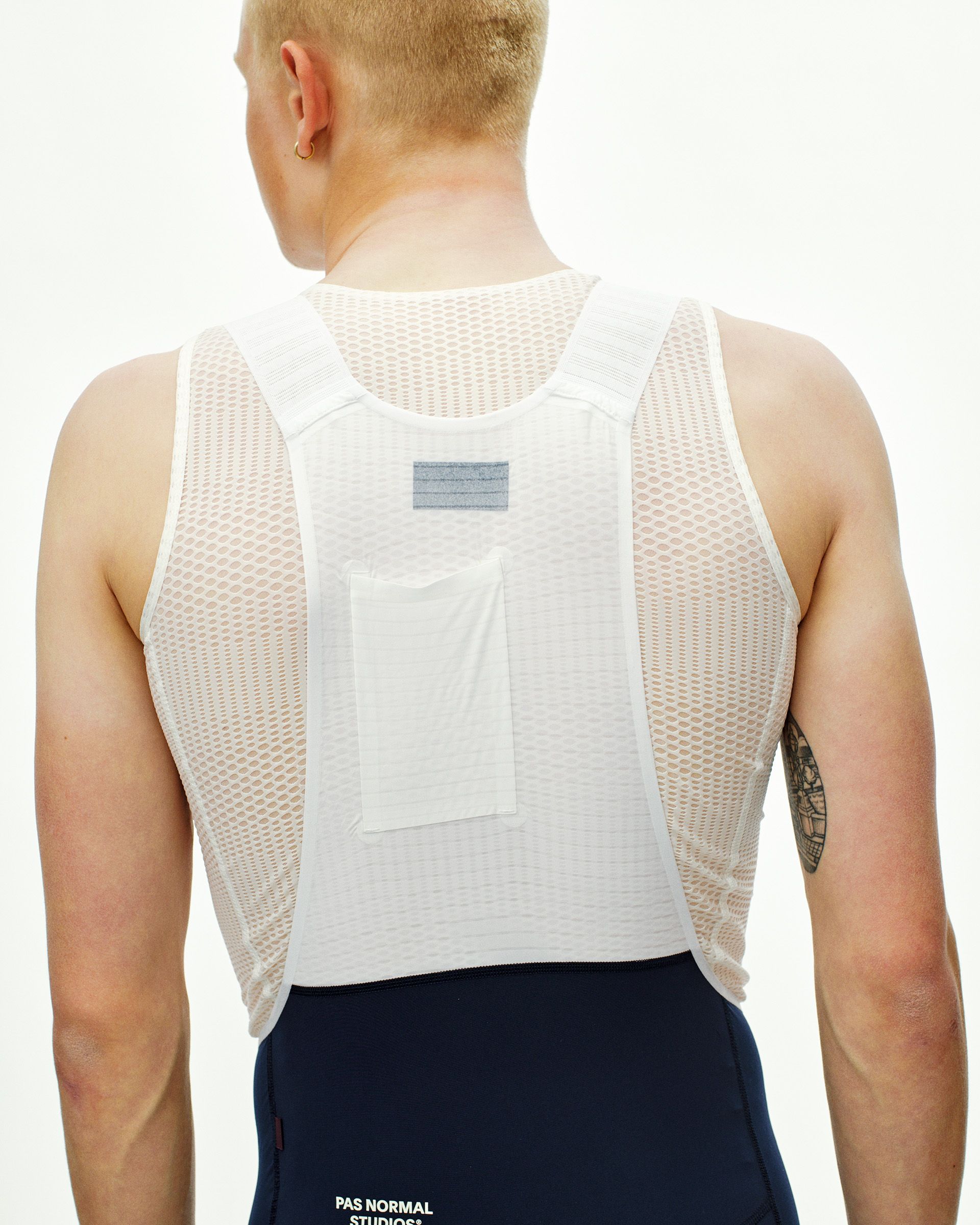 Navy Mechanism Pro cycling bibs on model, rear view with white mesh base layer visible
