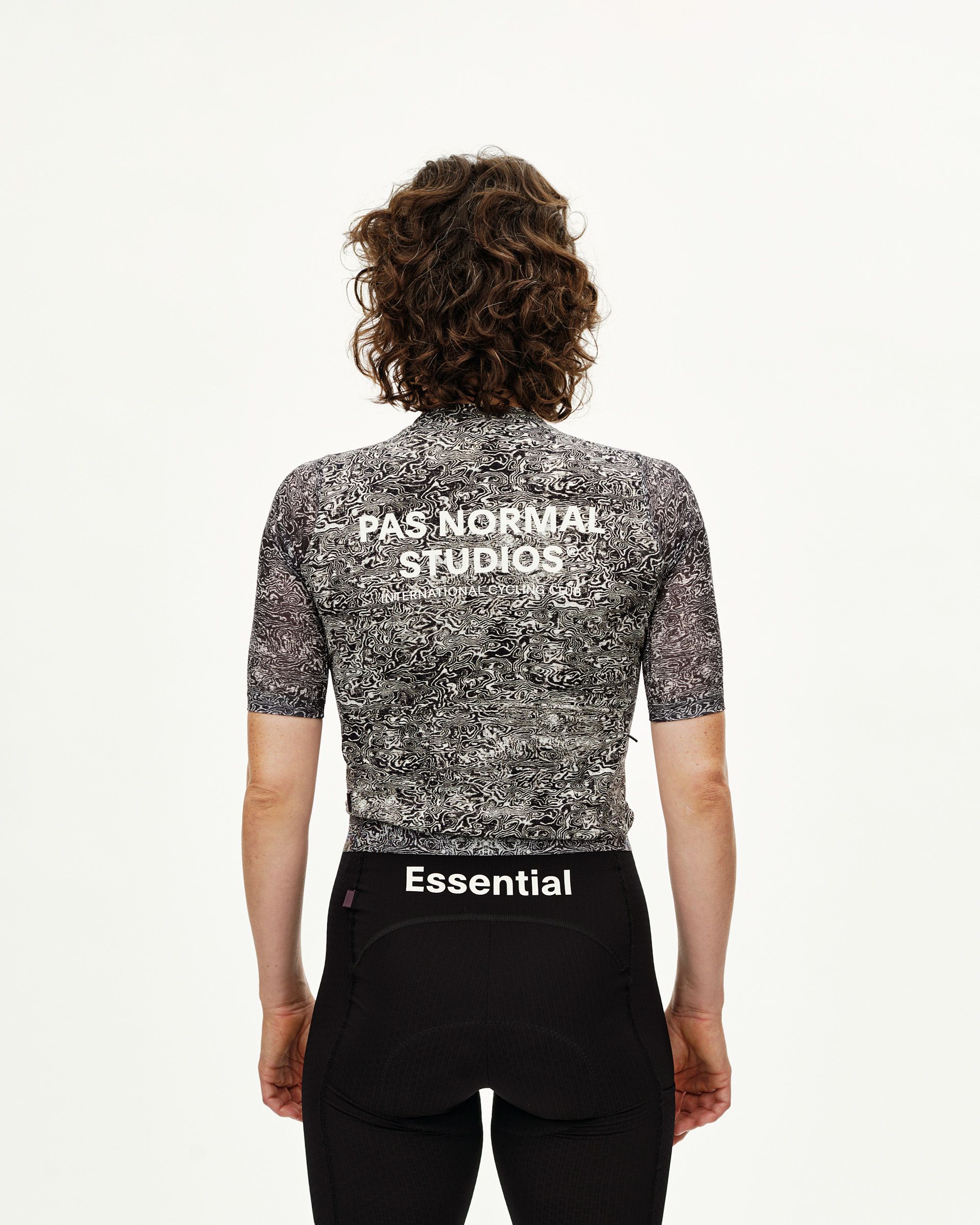 Off White Essential cycling jersey on model, rear view with abstract swirl print and white back logo