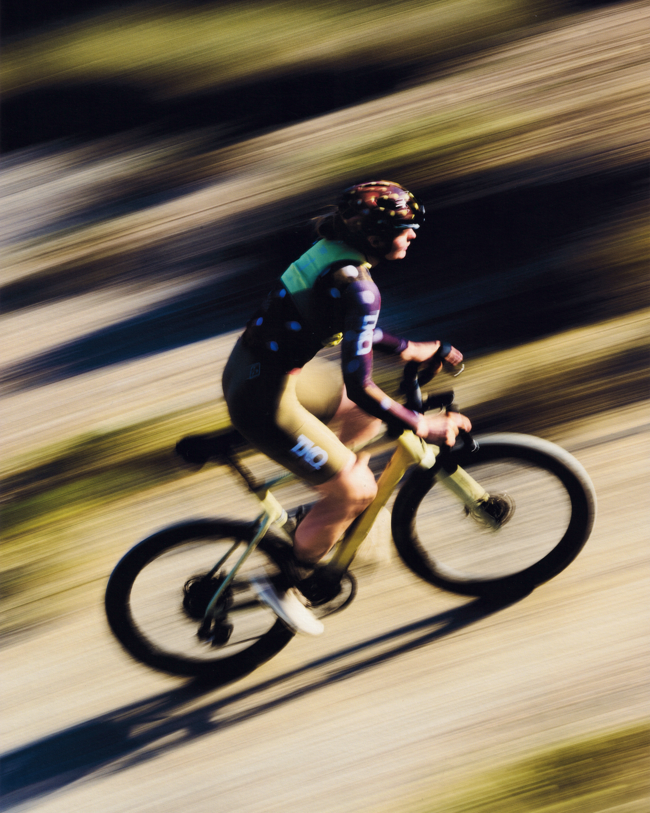 Cyclist in motion blur wearing colorful jersey on time trial bike