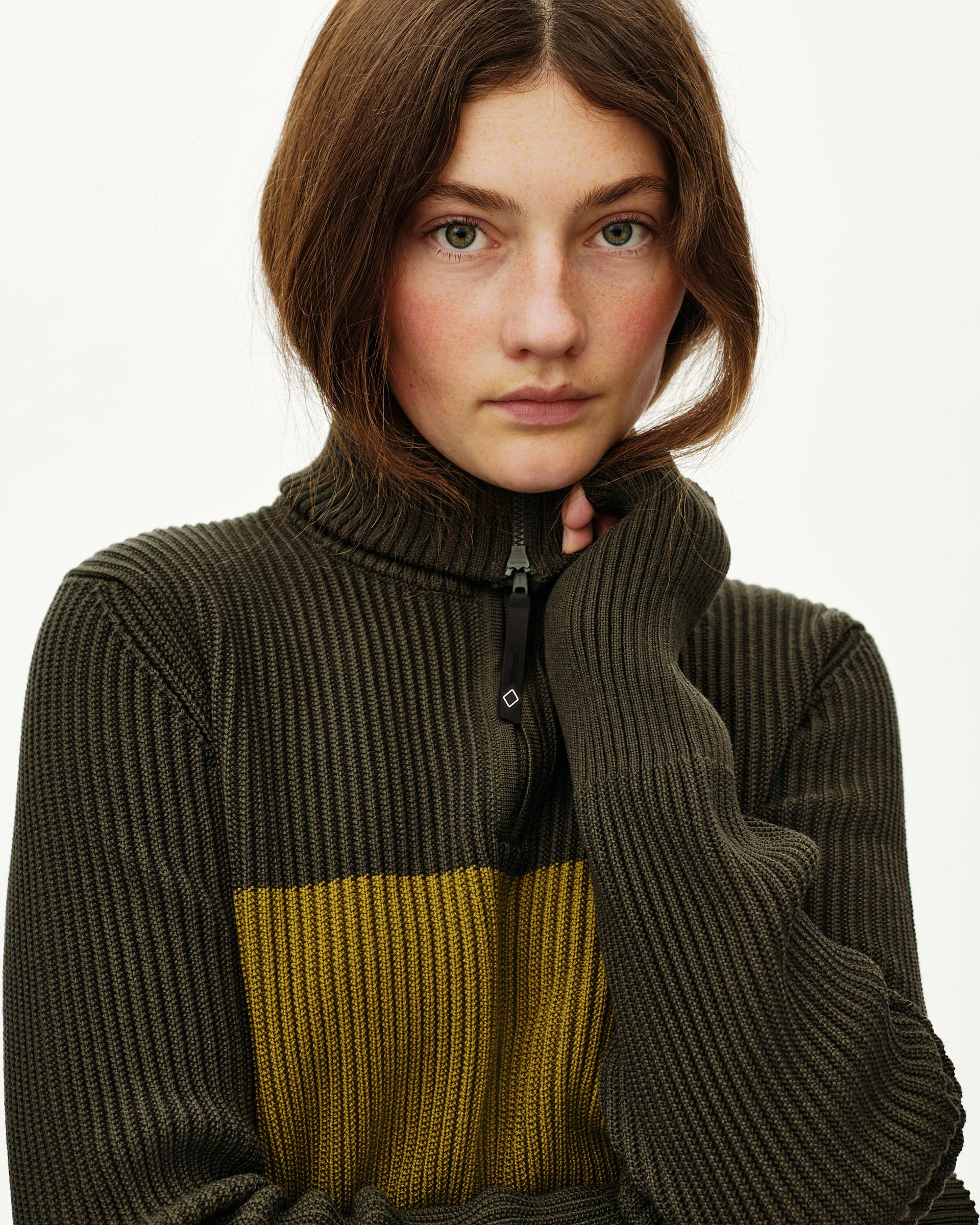 Olive Off-Race Merino Knit Half-Zip sweater on model, front view with contrast yellow chest stripe and half-zip collar