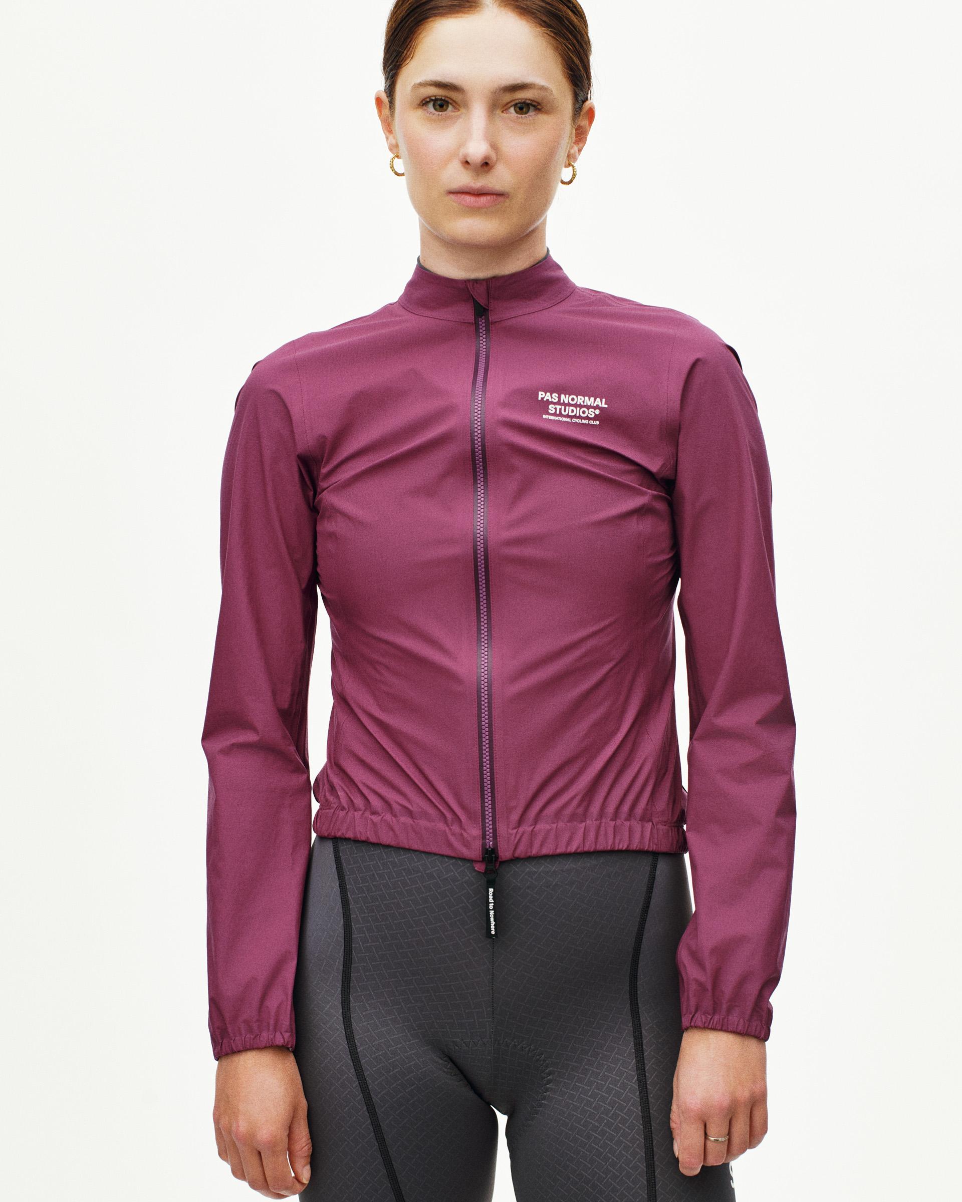 Purple Mechanism rain jacket on model with elastic waist hem and white chest logo