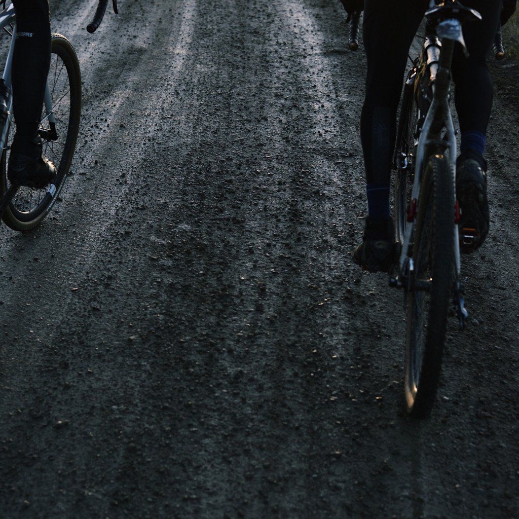 Cyclists on wet asphalt road surface