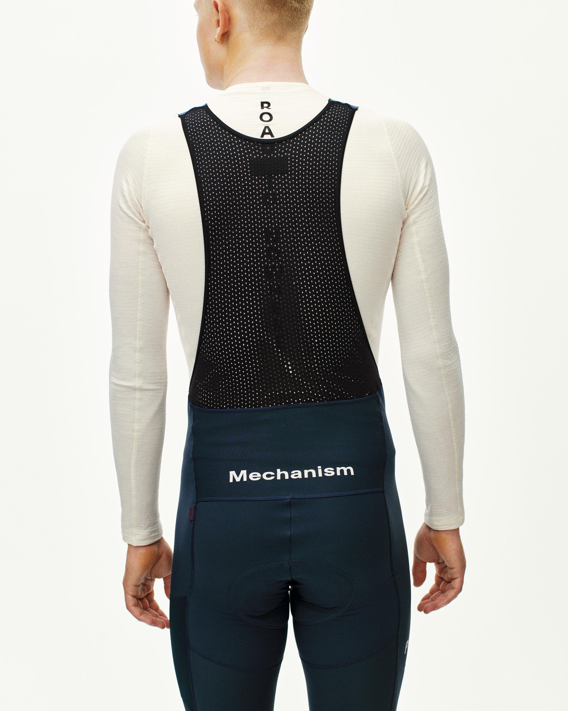 Navy Mechanism Deep Winter Long cycling bibs on model, rear view with perforated black panel