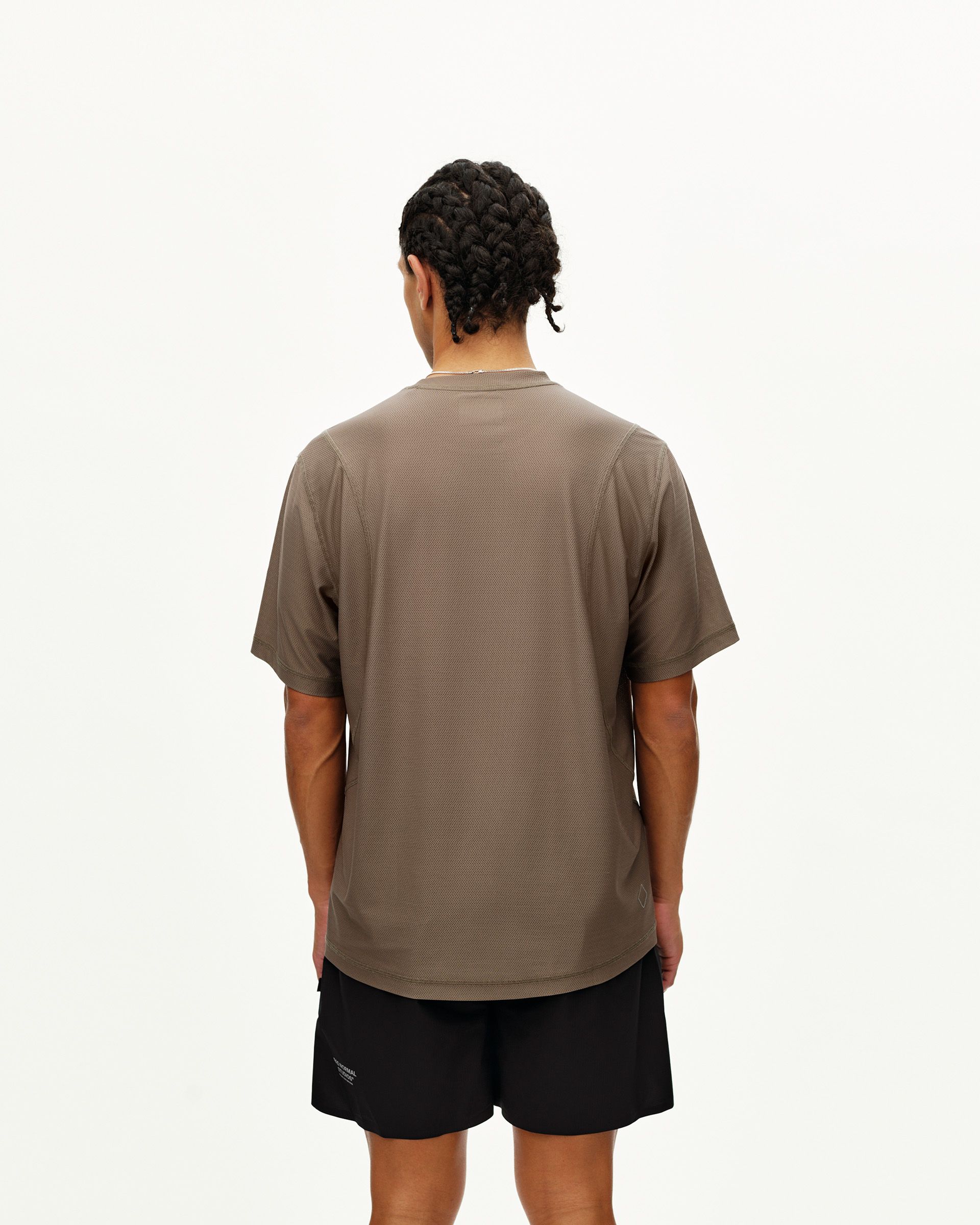 Stone Brown Balance T-shirt on model, rear view with curved hem and textured fabric